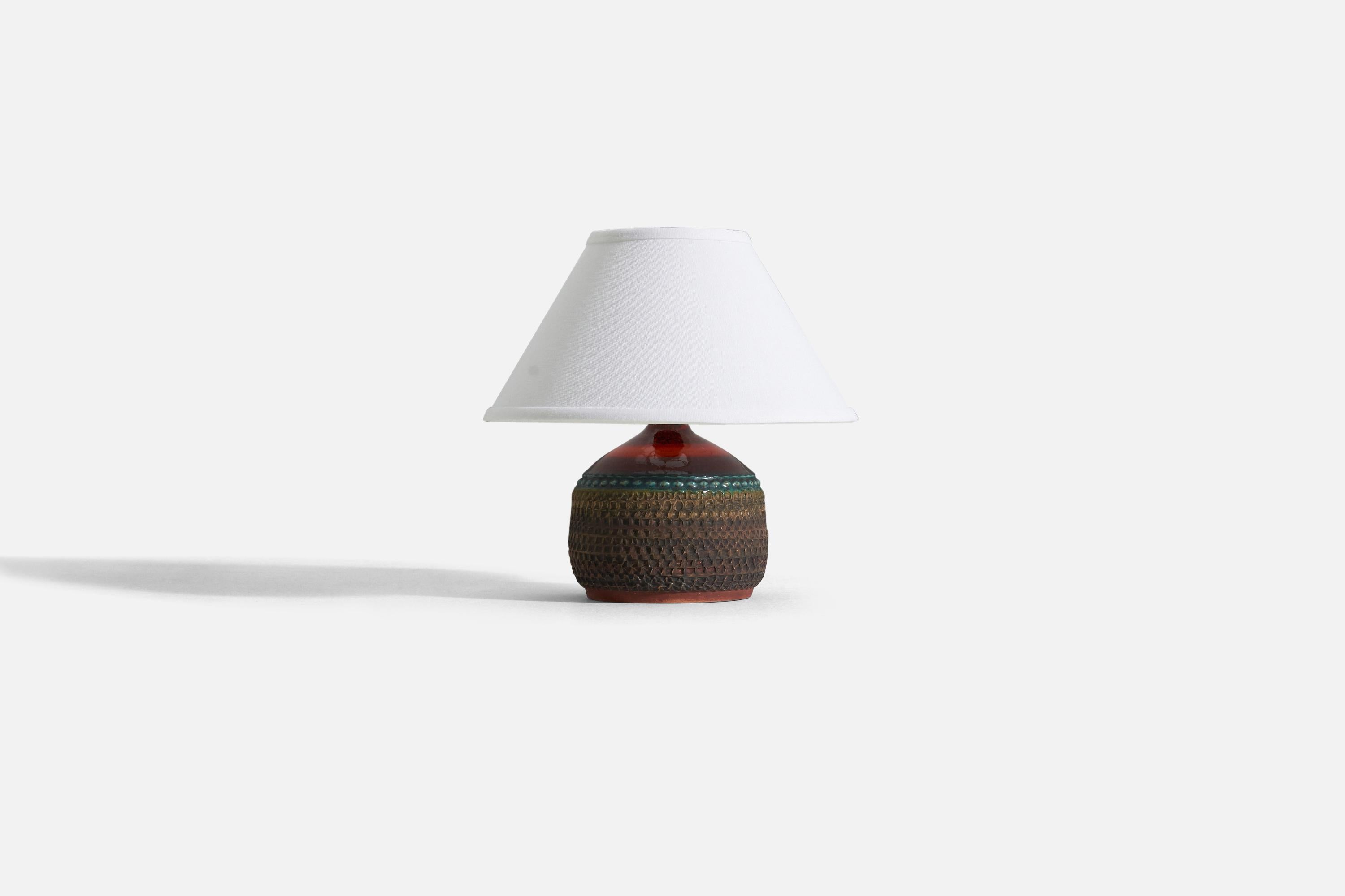 A brown, green, and red stoneware table lamp with simple incised decor by Klase Höganäs. Signed. 

Measurements listed are of lamp itself. Sold without lampshade.
For reference:
Measurements of shade (inches) : 4.5 x 10.25 x 6 (T x B x