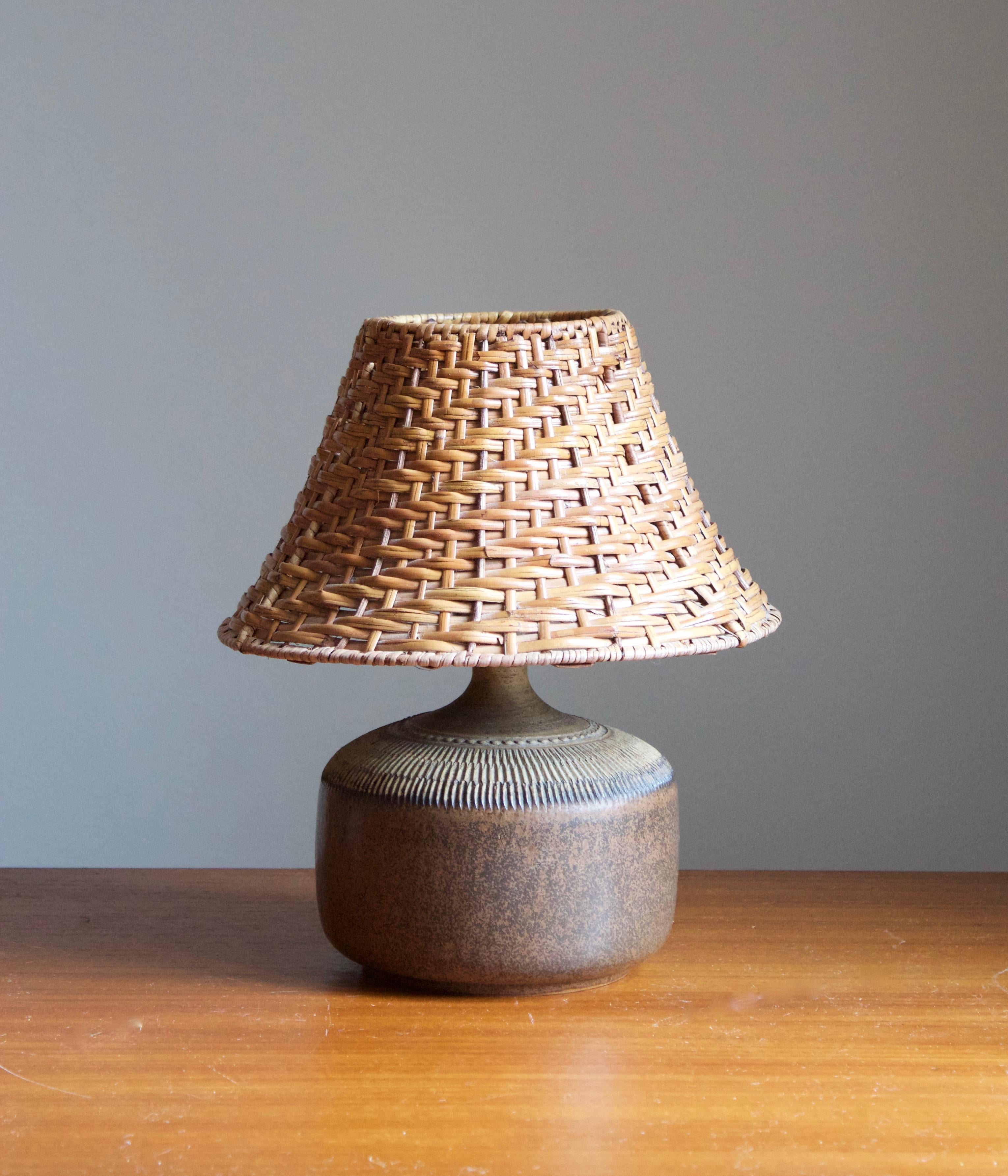 A table lamp by Klase Höganäs. In stoneware with simple incised decor. Signed. 

Dimensions stated exclude lampshade. Height includes socket. Vintage rattan lampshade of illustrated model can be included upon request.

Glaze features brown-green