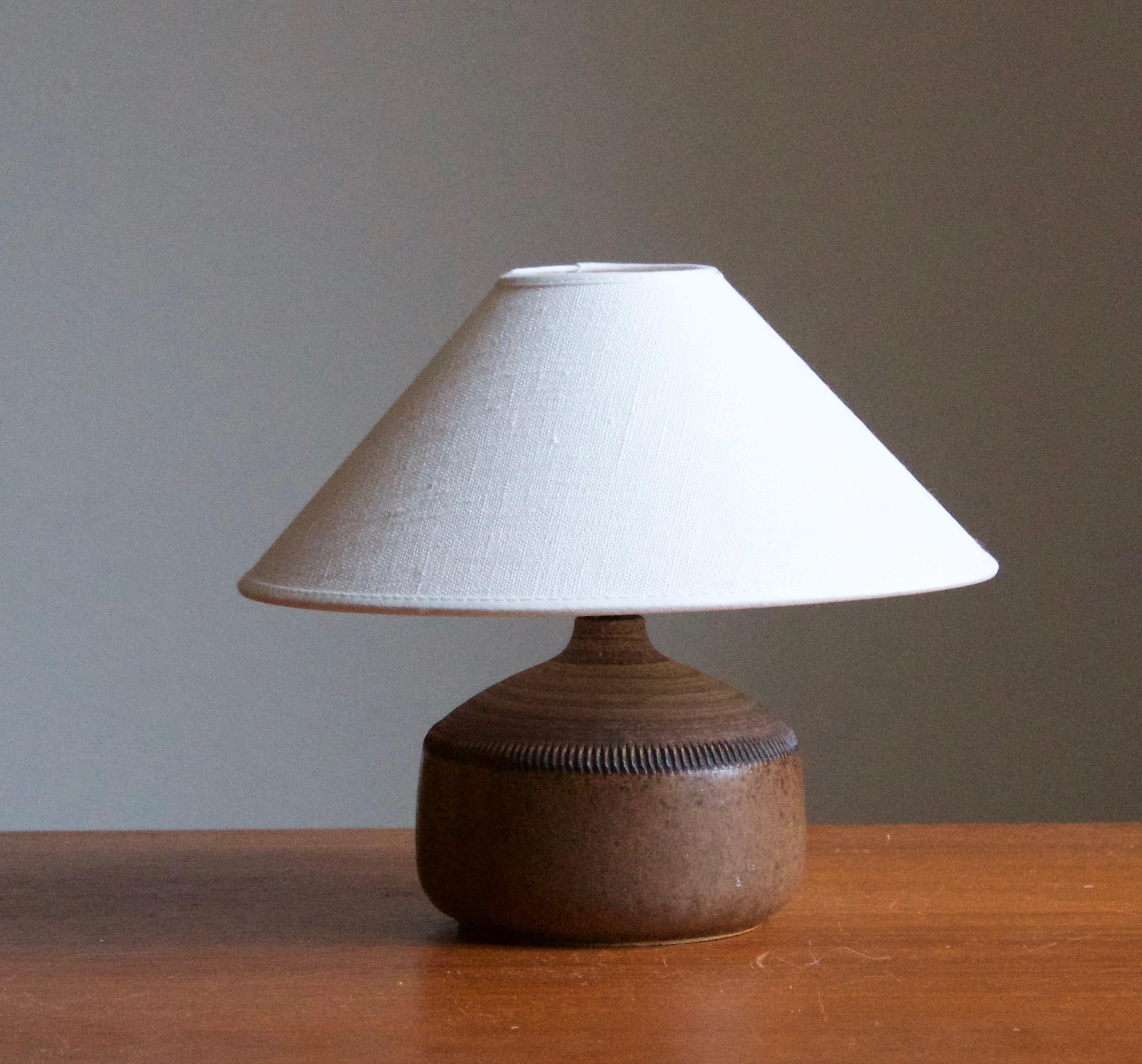 A table lamp by Klase Höganäs. In stoneware with simple incised decor. Signed. 

Dimensions stated exclude lampshade. Height includes socket. Sold without lampshade.