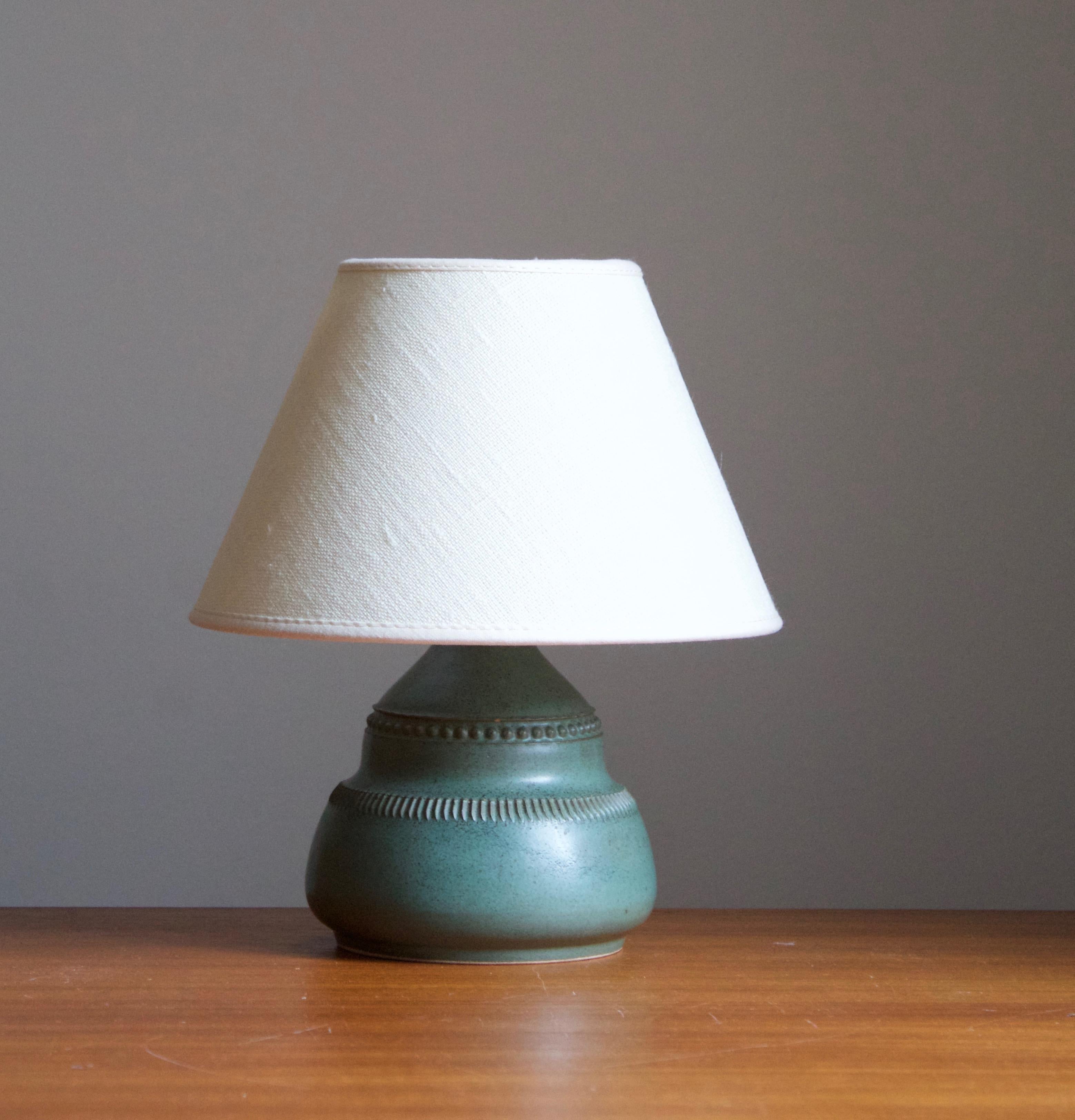 A small table lamp by Klase Höganäs. In stoneware with simple incised decor. Signed. 

Dimensions stated exclude lampshade. Height includes socket. Sold without lampshade.