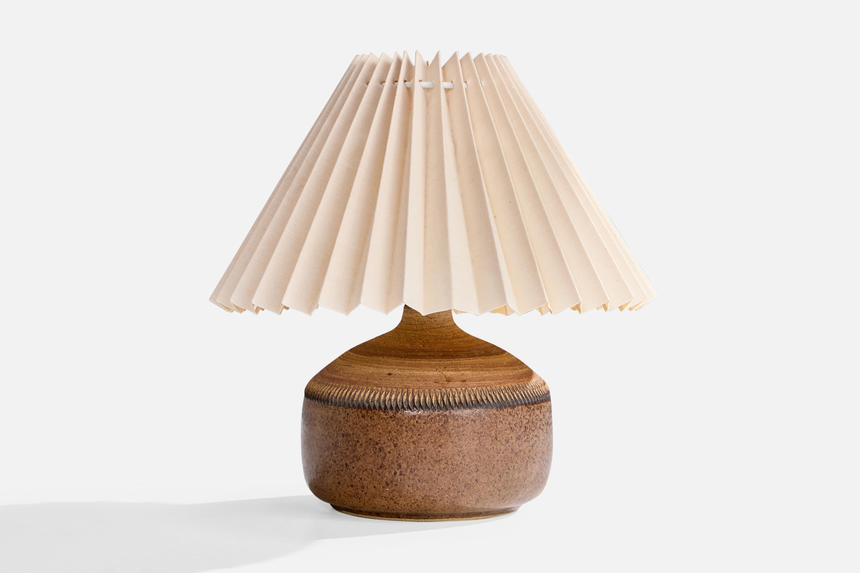A brown-glazed and incised stoneware and beige paper table lamp designed and produced in Sweden, c. 1960s.

Designer logo in bottom

Dimensions of Lamp with Shade (inches): 6.25