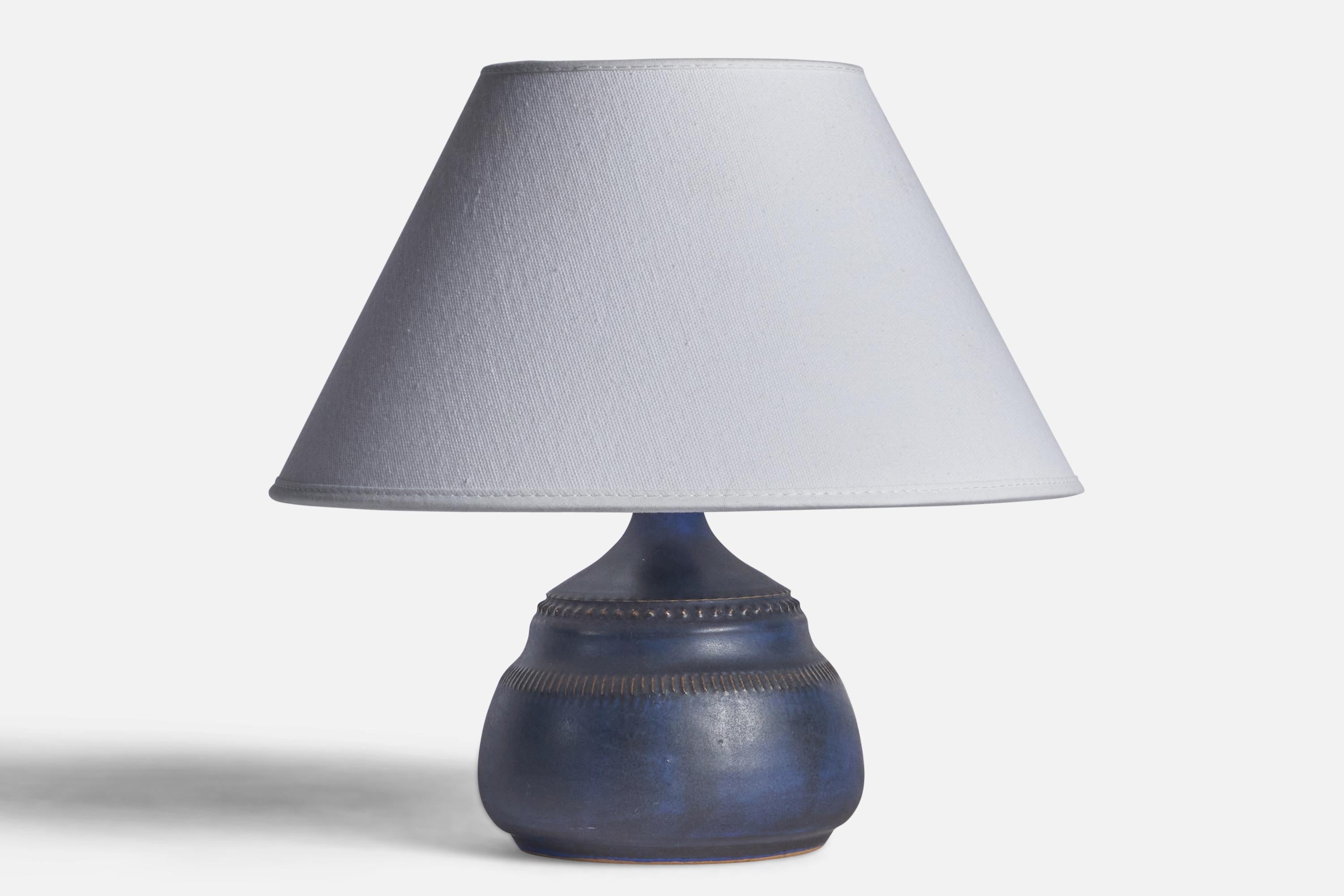 A blue-glazed and incised stoneware table lamp designed and produced by Klase Höganäs, Sweden, 1960s.

Dimensions of Lamp (inches): 7.75” H x 4.55” Diameter
Dimensions of Shade (inches): 7” Top Diameter x 10” Bottom Diameter x 5.5” H 
Dimensions of