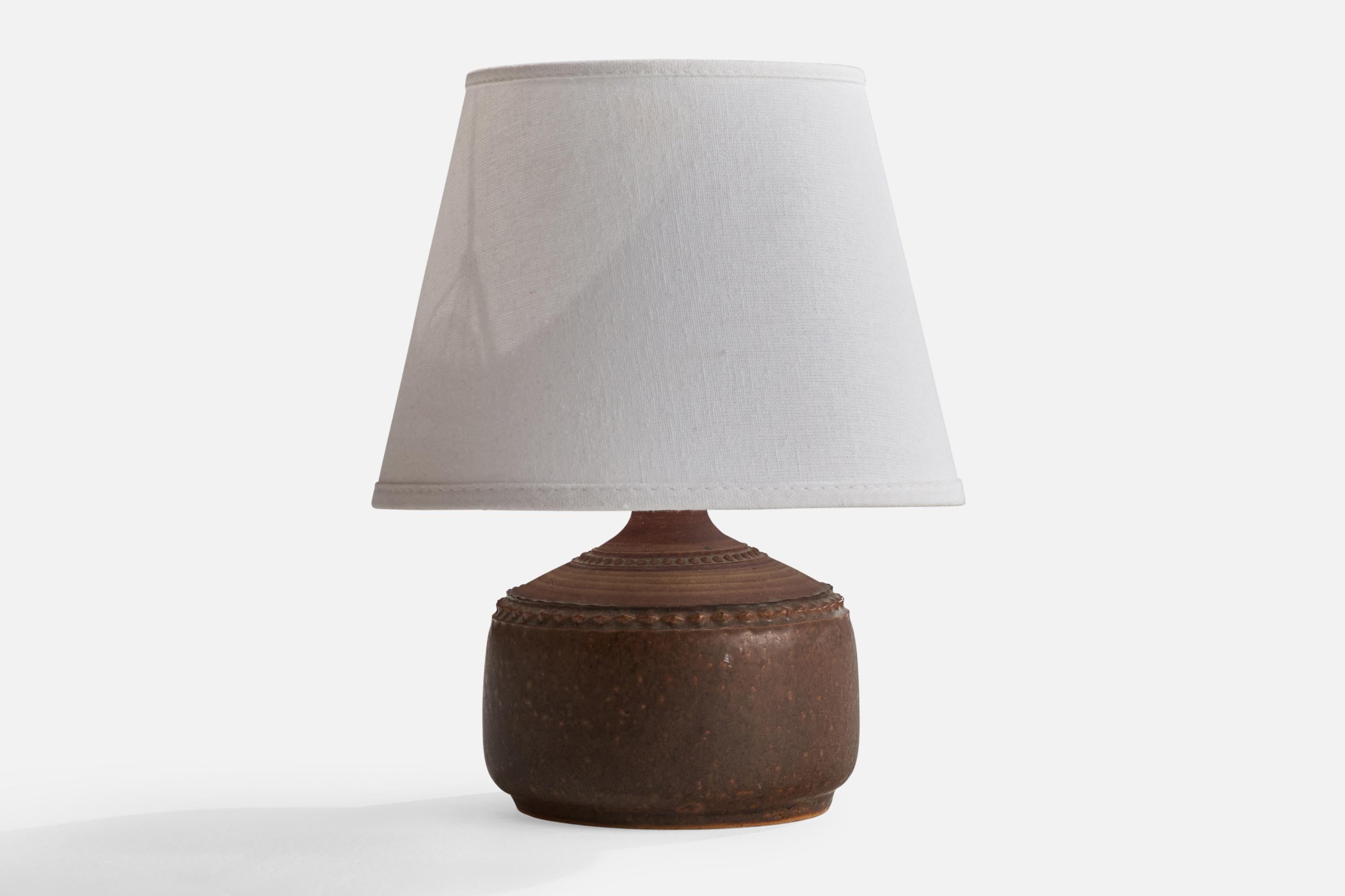 A brown-glazed stoneware table lamp designed and produced by Klase Höganäs, Sweden, 1960s.

Overall Dimensions (inches): 10.25” H x 5” W x 5” D
Stated dimensions include shade.
Bulb Specifications: E-26 Bulb
Number of Sockets: 1
All lighting will be