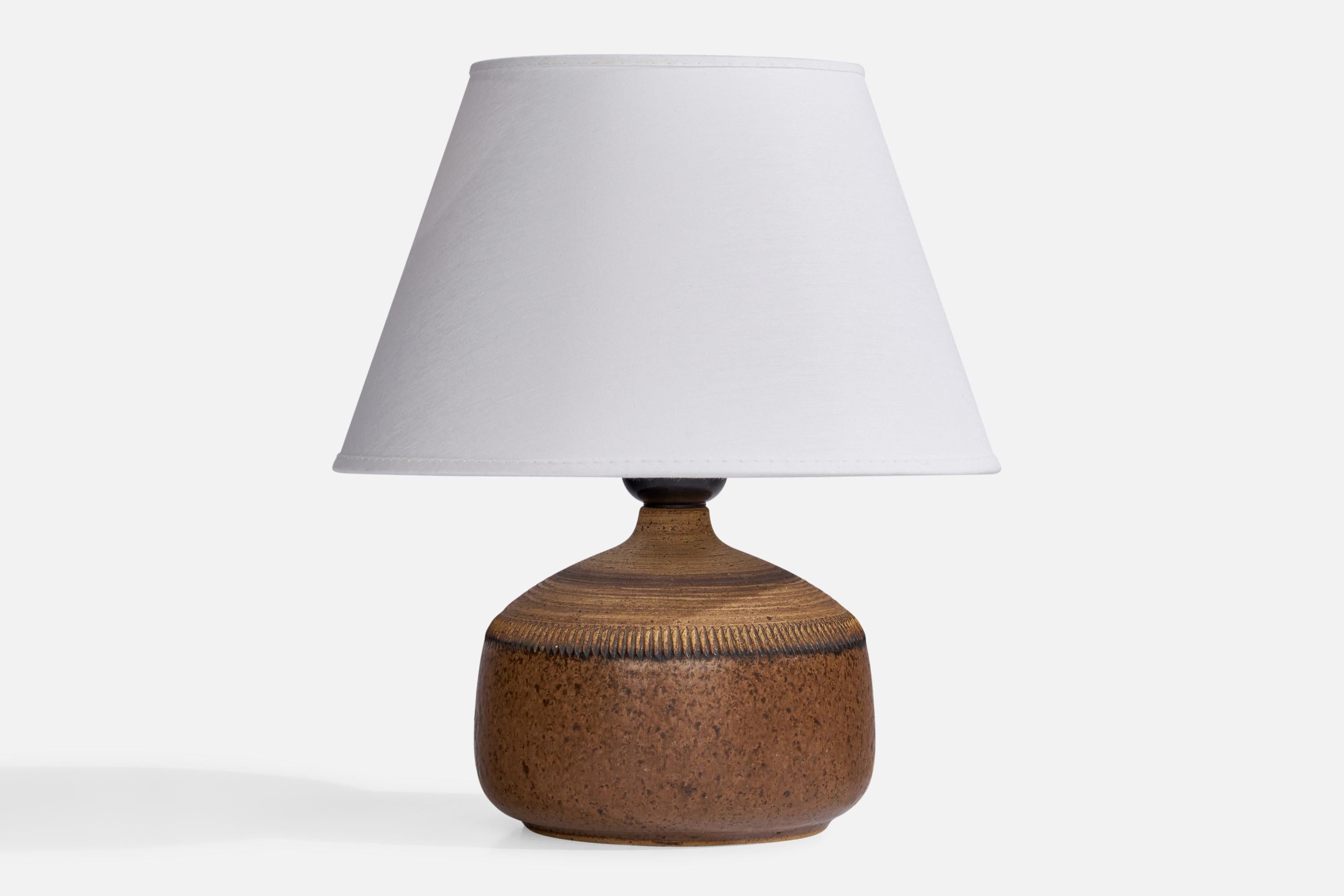 A brown-glazed stoneware table lamp designed and produced by Klase Höganäs, Sweden, 1960s.

Dimensions of Lamp (inches): 6.25” H x 5” Diameter
Dimensions of Shade (inches): 4.75” Top Diameter x 8.25” Bottom Diameter x 5.25”
Dimensions of Lamp with