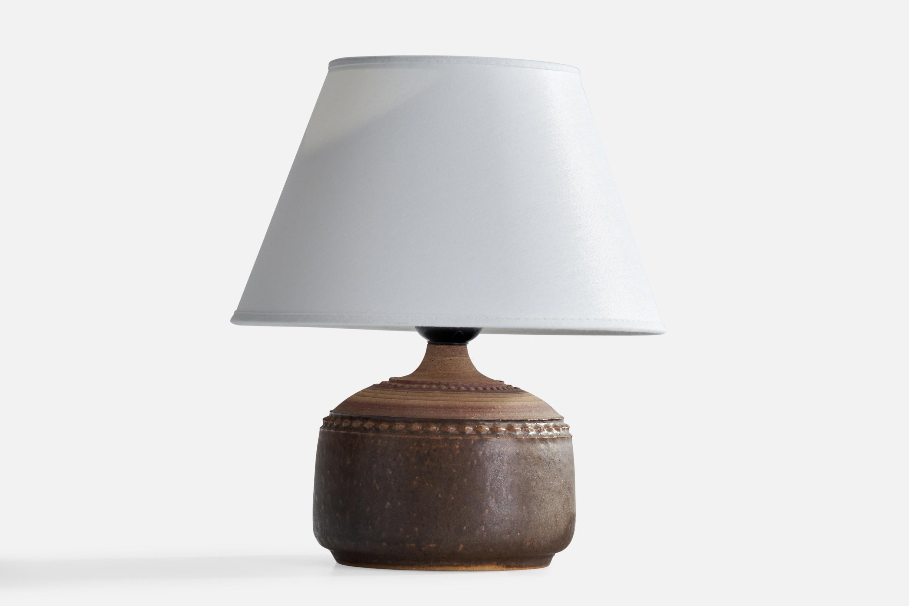 A brown-glazed stoneware table lamp designed and produced in Sweden, 1960s.

Dimensions of Lamp (inches): 6.5” H x 5.25” Diameter
Dimensions of Shade (inches): 4.75” Top Diameter x 8.25” Bottom Diameter x 5.25” H
Dimensions of Lamp with Shade