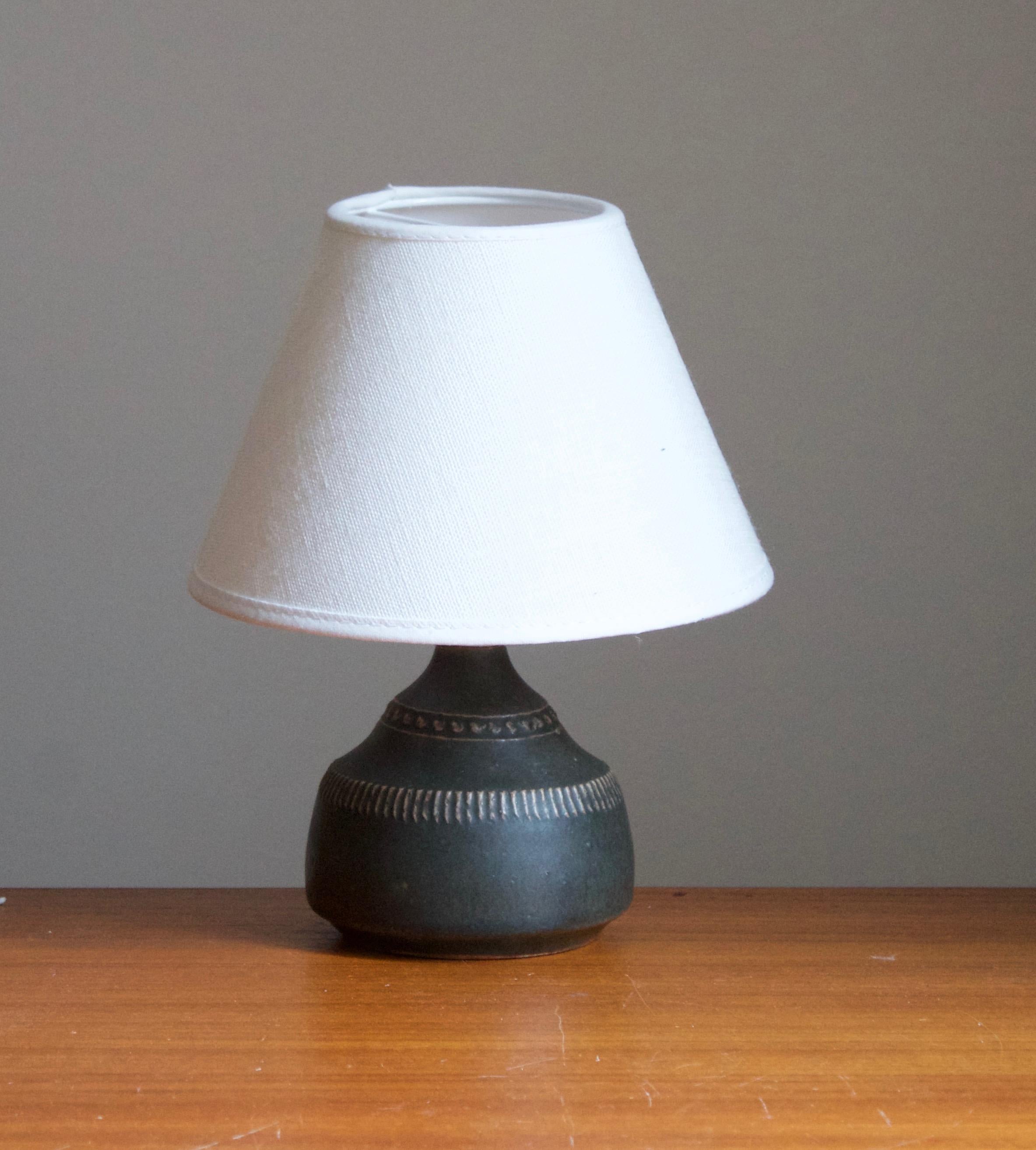 A very small table lamp by Klase Höganäs. In stoneware with simple incised decor. Signed. 

Dimensions stated exclude lampshade. Height includes socket. Sold without lampshade.