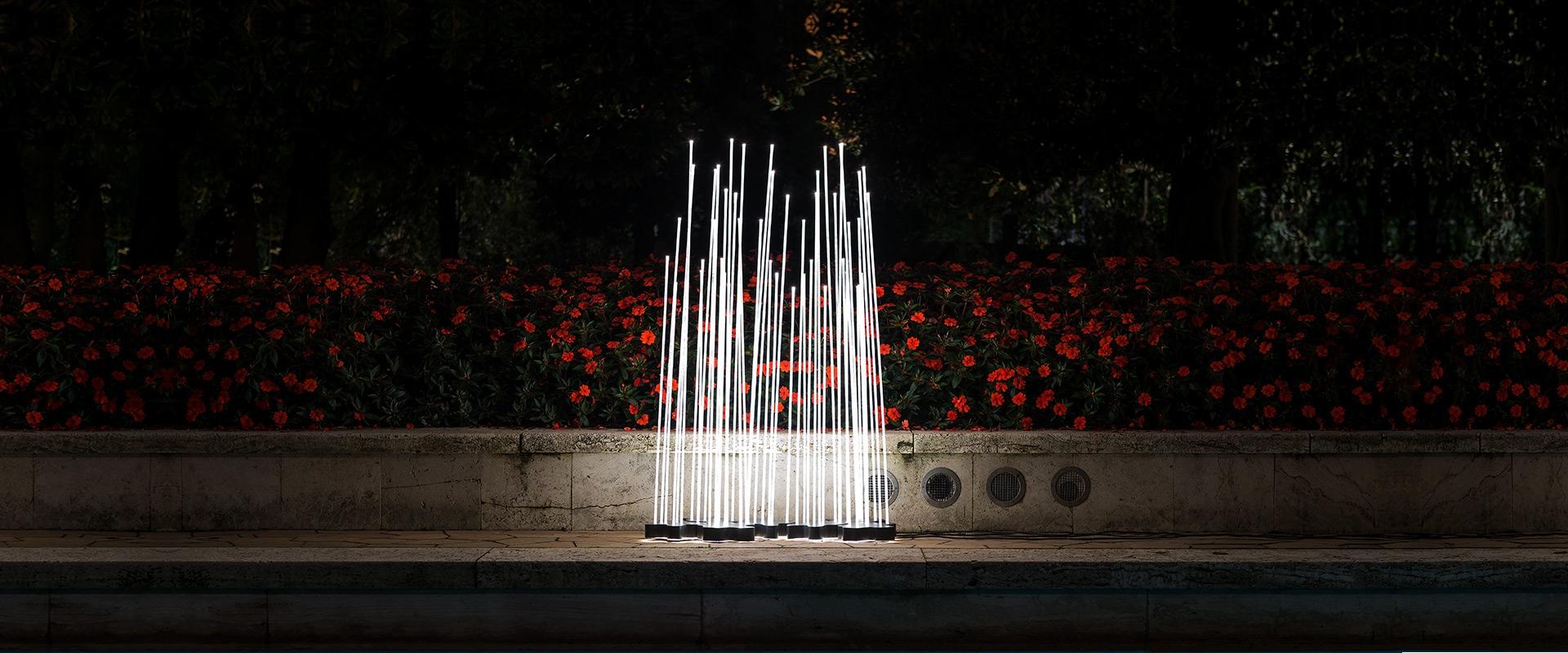 Lampadaire d'intérieur ou d'extérieur 'Reeds Triple' de Klaus Begasse pour Artemide. 

Cette lampe sculpturale se compose d'une base constituée d'un boîtier en polycarbonate transparent installé entre 2 plaques en acier inoxydable fixées à l'aide de
