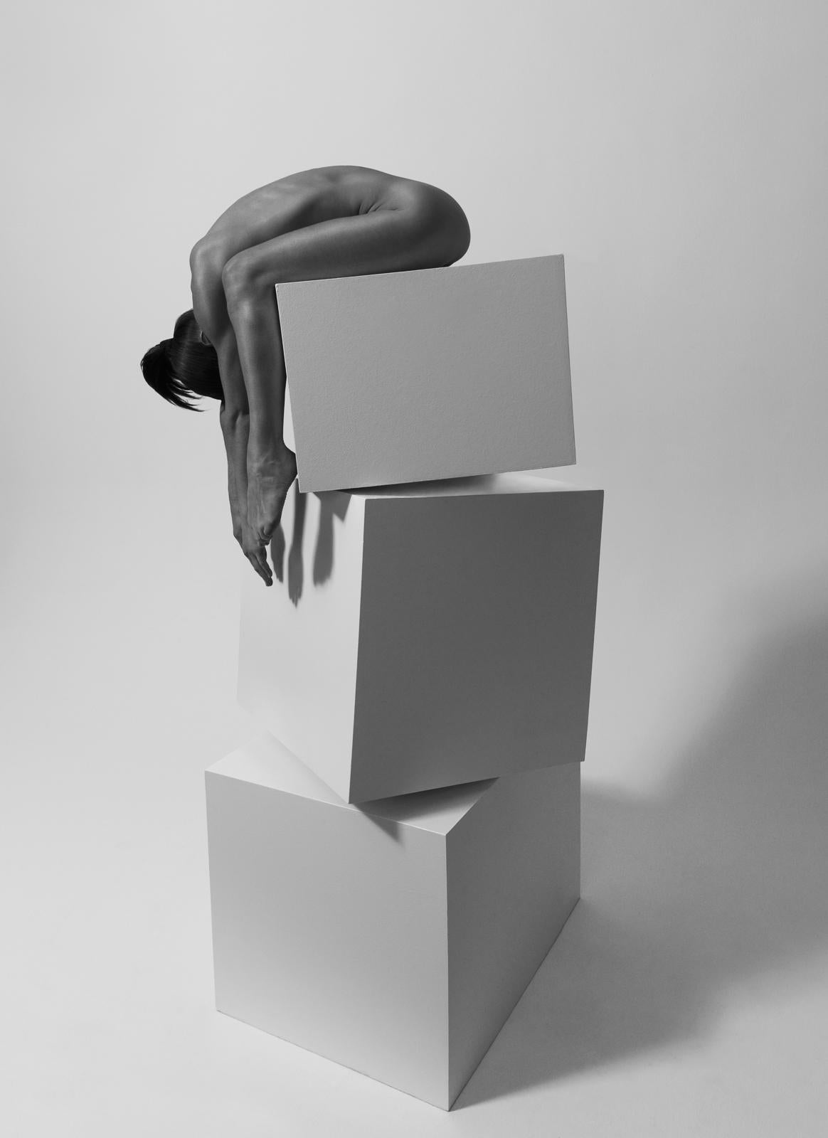 154.08.11 is a limited-edition photograph by contemporary artist Klaus Kampert. It belongs to the series "Dancing the Cubes". In order to resemble typographic characters, Klaus Kampert poses his models in this series in almost geometric and