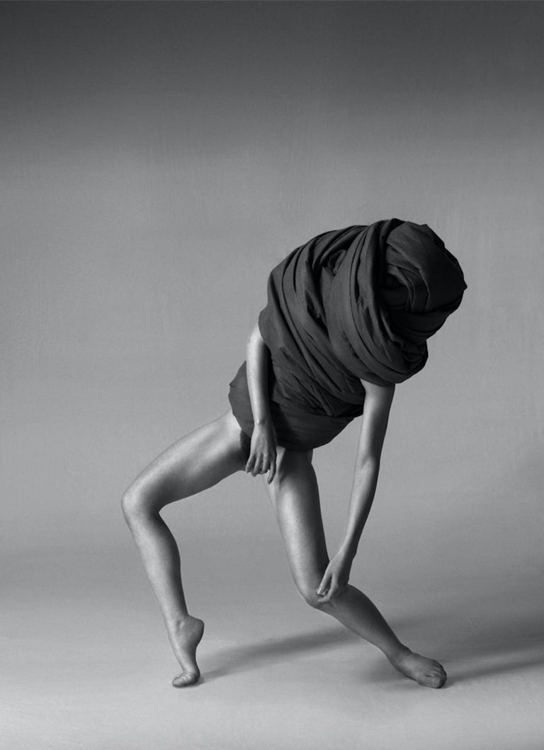 168.07.12 is a limited-edition black & white photograph by contemporary artist Klaus Kampert from the series entitled Wrapped. In this series, Klaus Kampert uses fabric to partially cover his models. The poses adopted produce enigmatic silhouettes