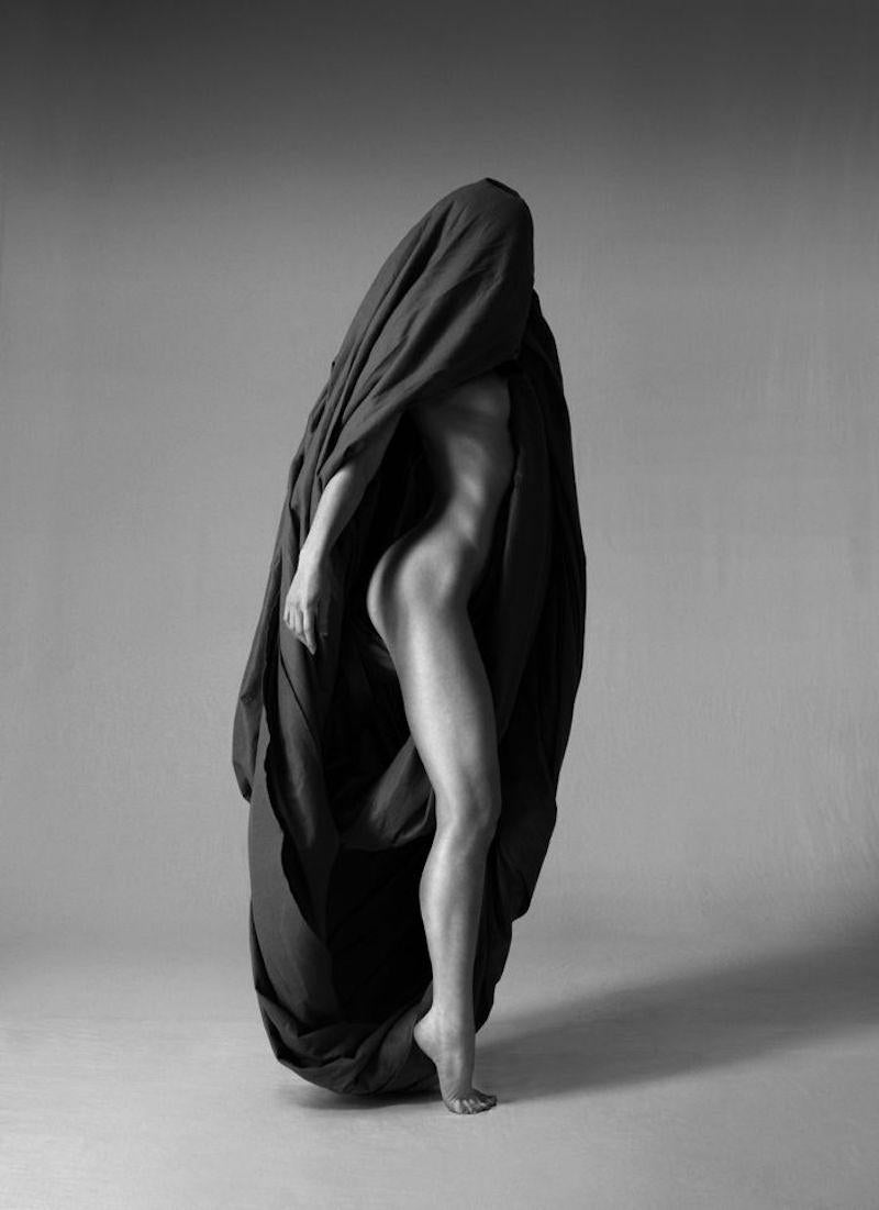 168.04.12 ist eine Schwarz-Weiß-Fotografie des zeitgenössischen Künstlers Klaus Kampert aus der Serie Wrapped in limitierter Auflage. In dieser Serie verwendet Klaus Kampert Stoff, um seine Modelle teilweise zu verhüllen. Die eingenommenen Posen