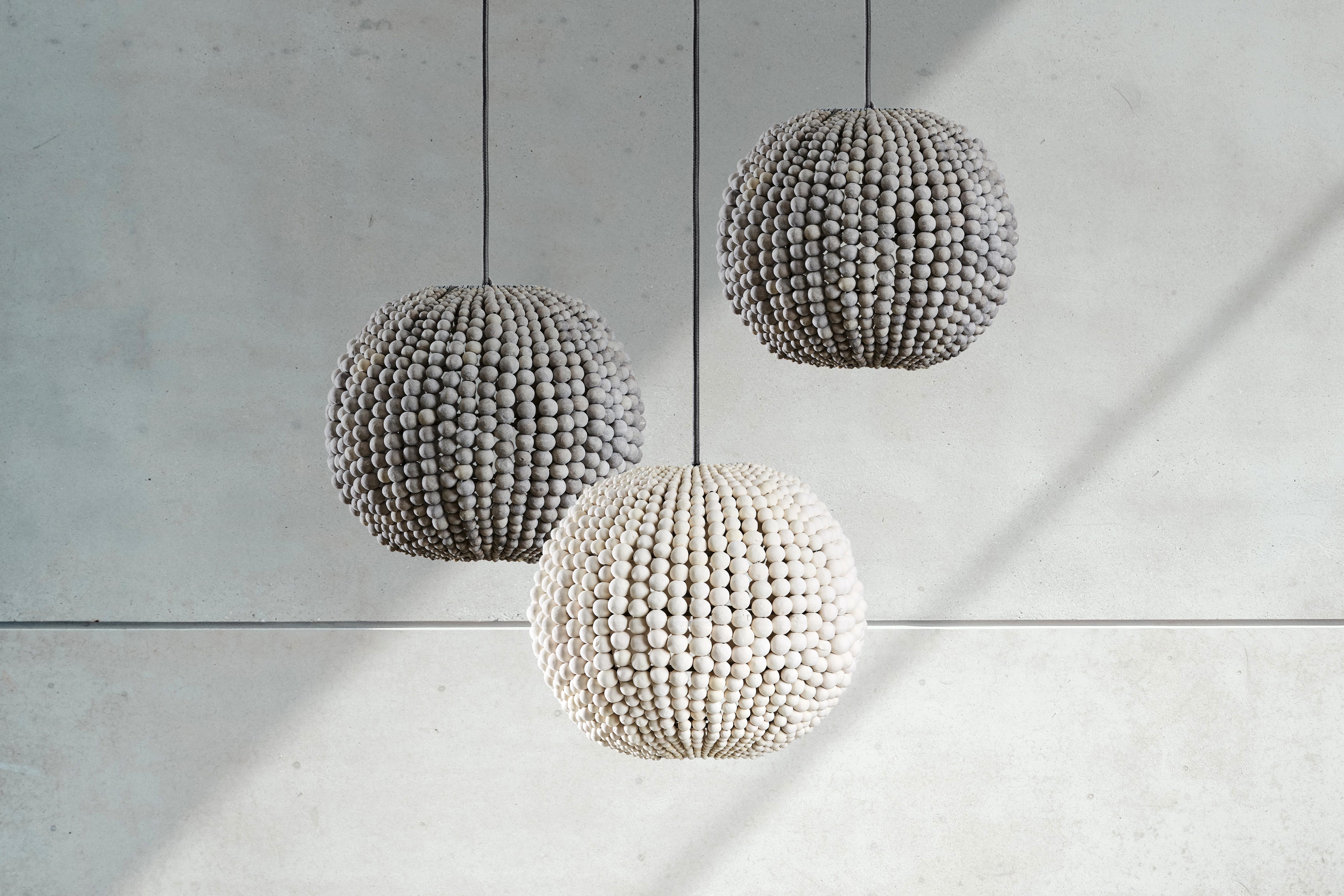 Statement clay beaded lighting, that can be suspended as a single, or in a cluster for maximum impact. Lovers of all things round will rejoice in each clay bead hand threaded onto its sphere shaped frame, creating an eye catching pendant with zero
