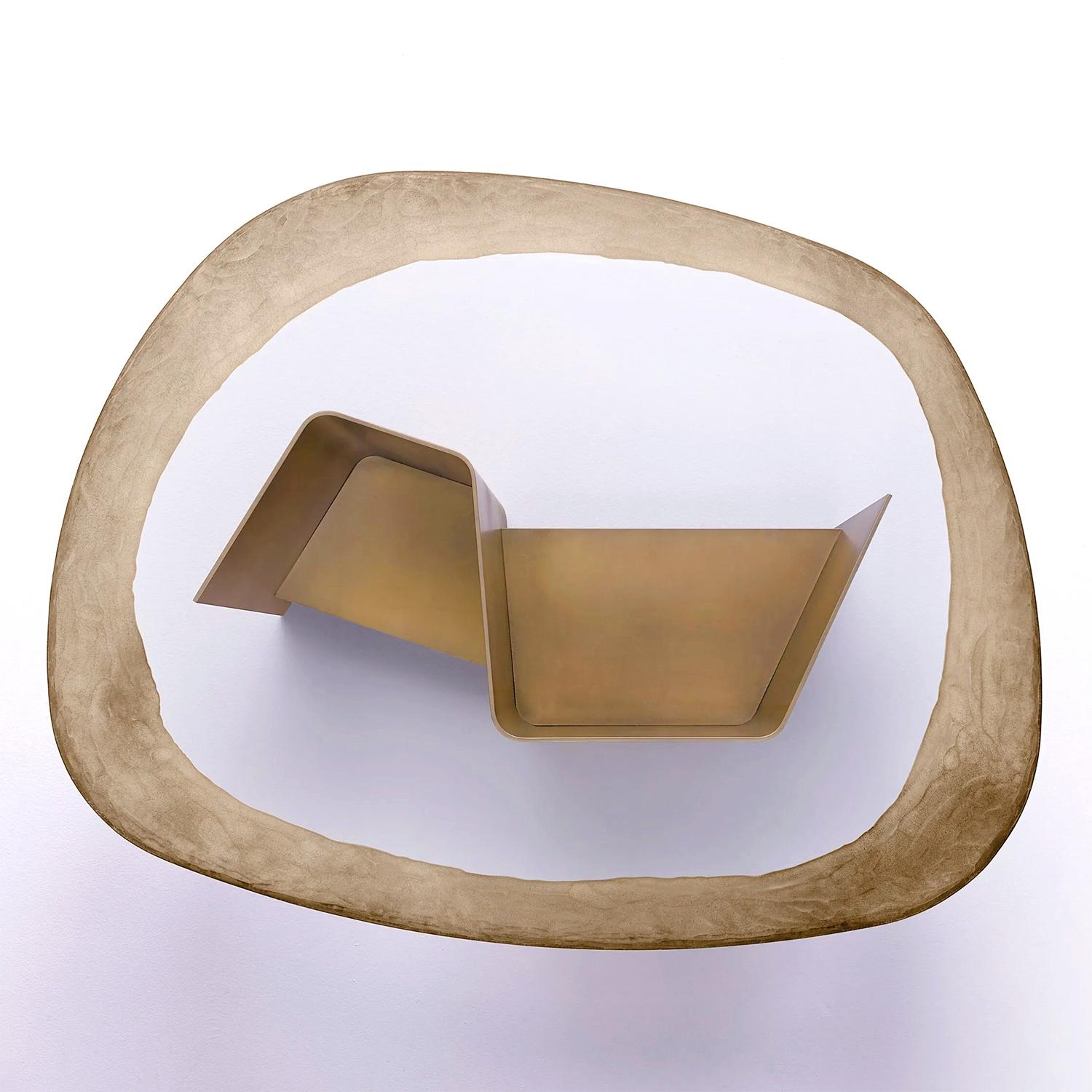 Coffee Table Kleo with base structure in burnished 
brass finish with a small shelf. With clear glass table
top, 15mm thickness, top engraved on all the edge
with silver and diamond grinding wheel.

