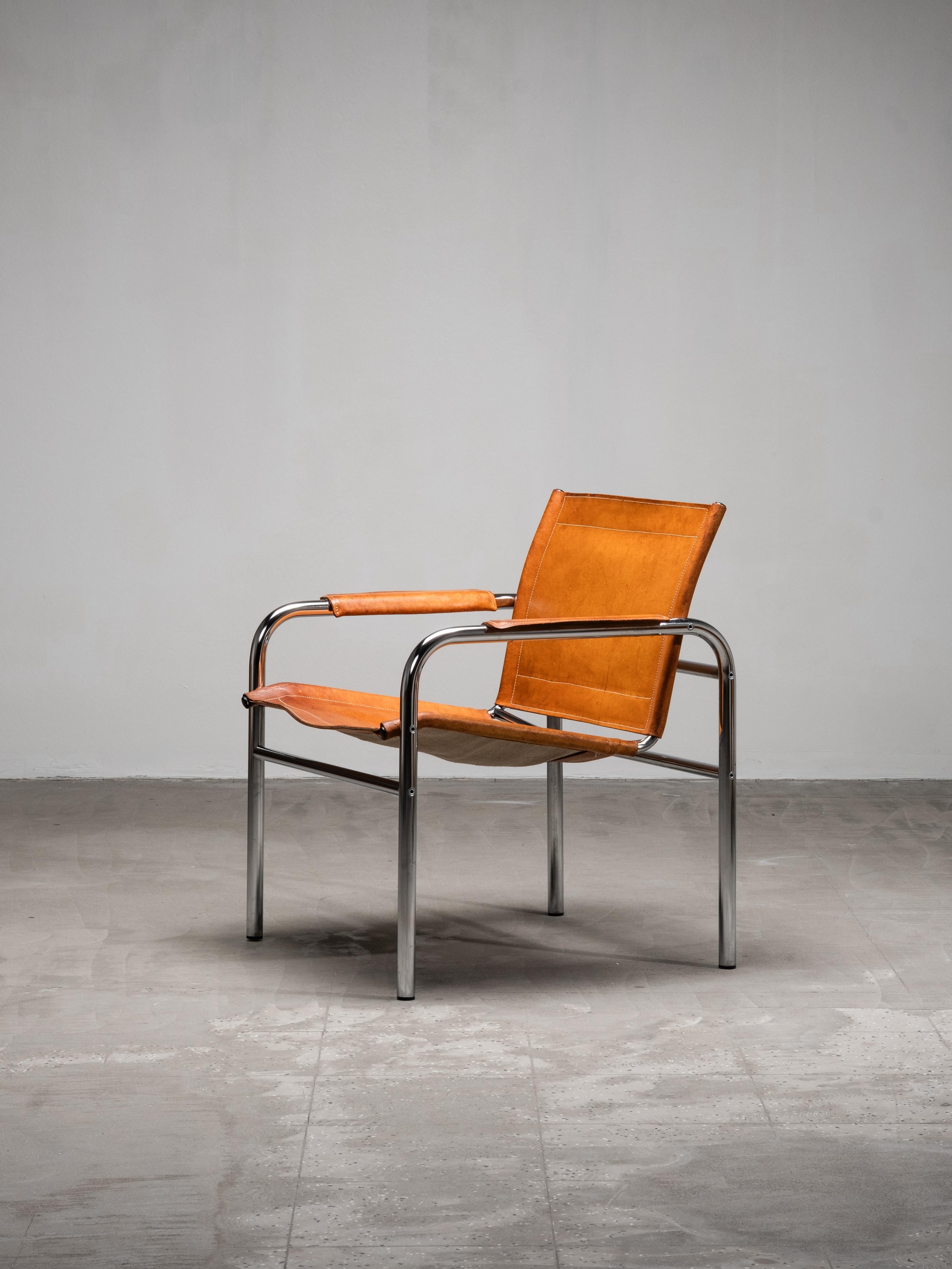 An original “Klinte” easy chair designed by Tord Björklund for IKEA in the 1980s. The chair features a tubular steel frame with a suspended seat and backrest in natural saddle leather. The armrests are wrapped in matching leather, softening the
