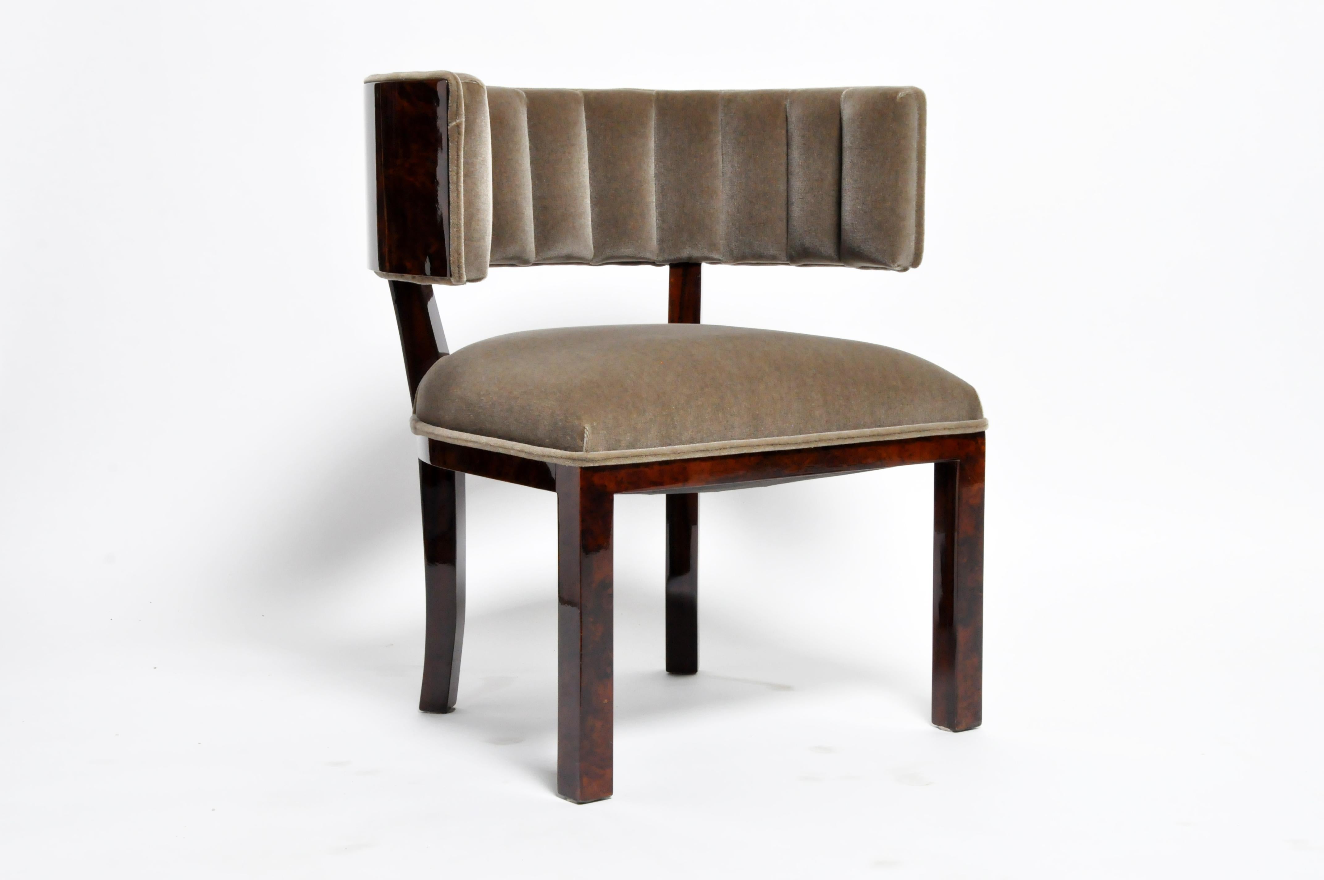 This luxurious klismos chair exudes modernist refinement. Burled walnut veneer is offset by a smooth, tufted upholstery. The juxtaposition of plush materials and stream-lined form signifies the modernist's reverence for both comfort and opulence.