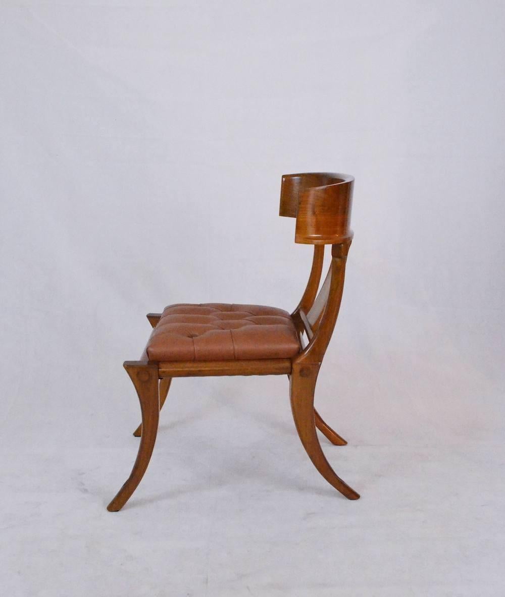 De la collection de chaises Klismos personnalisables, Pescetta présente ici une chaise avec des pieds en sabre, une finition en bois de noyer naturel brillant et des sièges en cuir capitonné (avec boutons). Disponible dans d'autres couleurs et