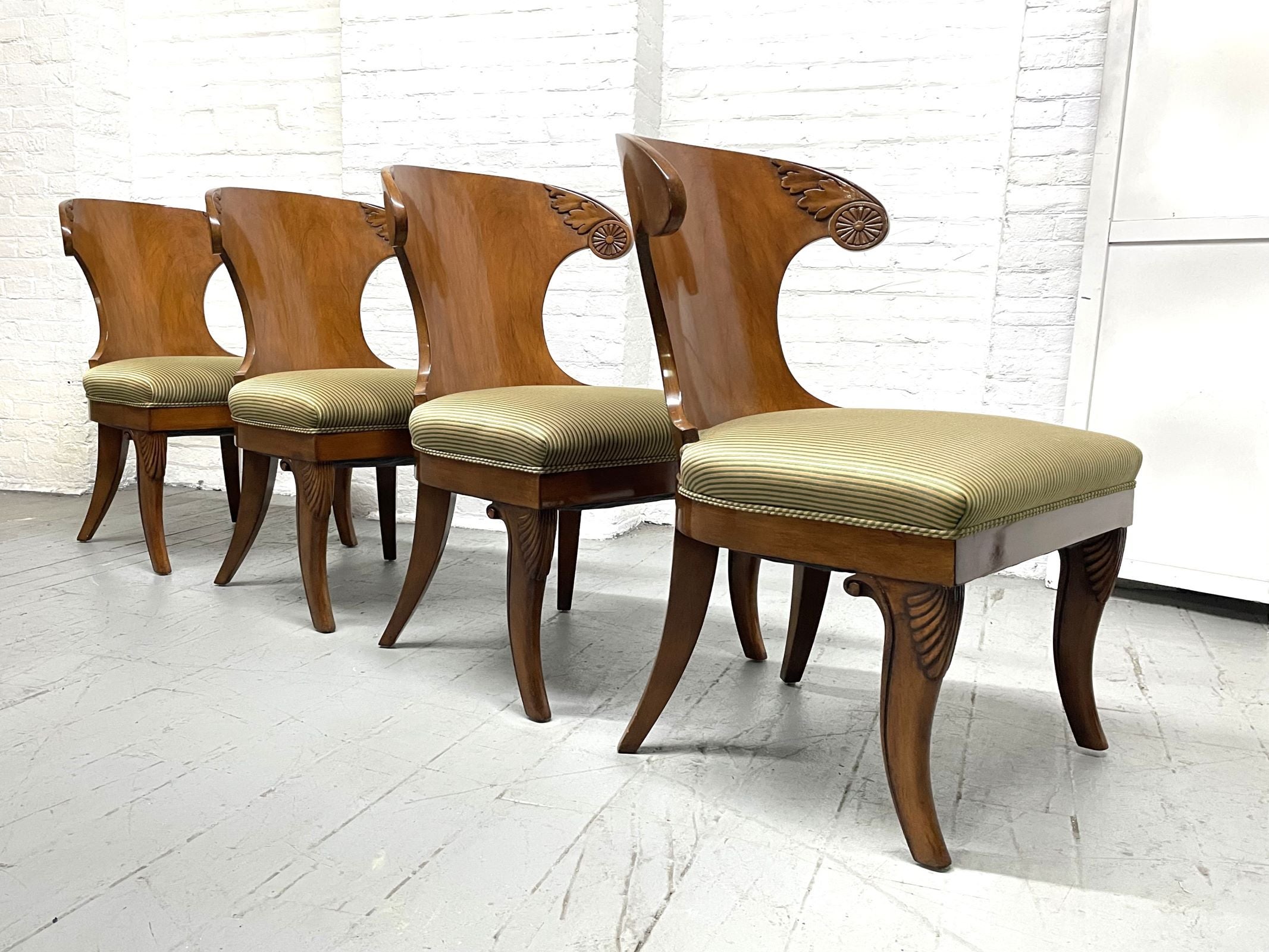Set of 4 Klismos Style Solid Walnut Dining Chairs.  The chairs have cushioned seats, original fabric with a decorative carved pattern to the top sides of the chairs.