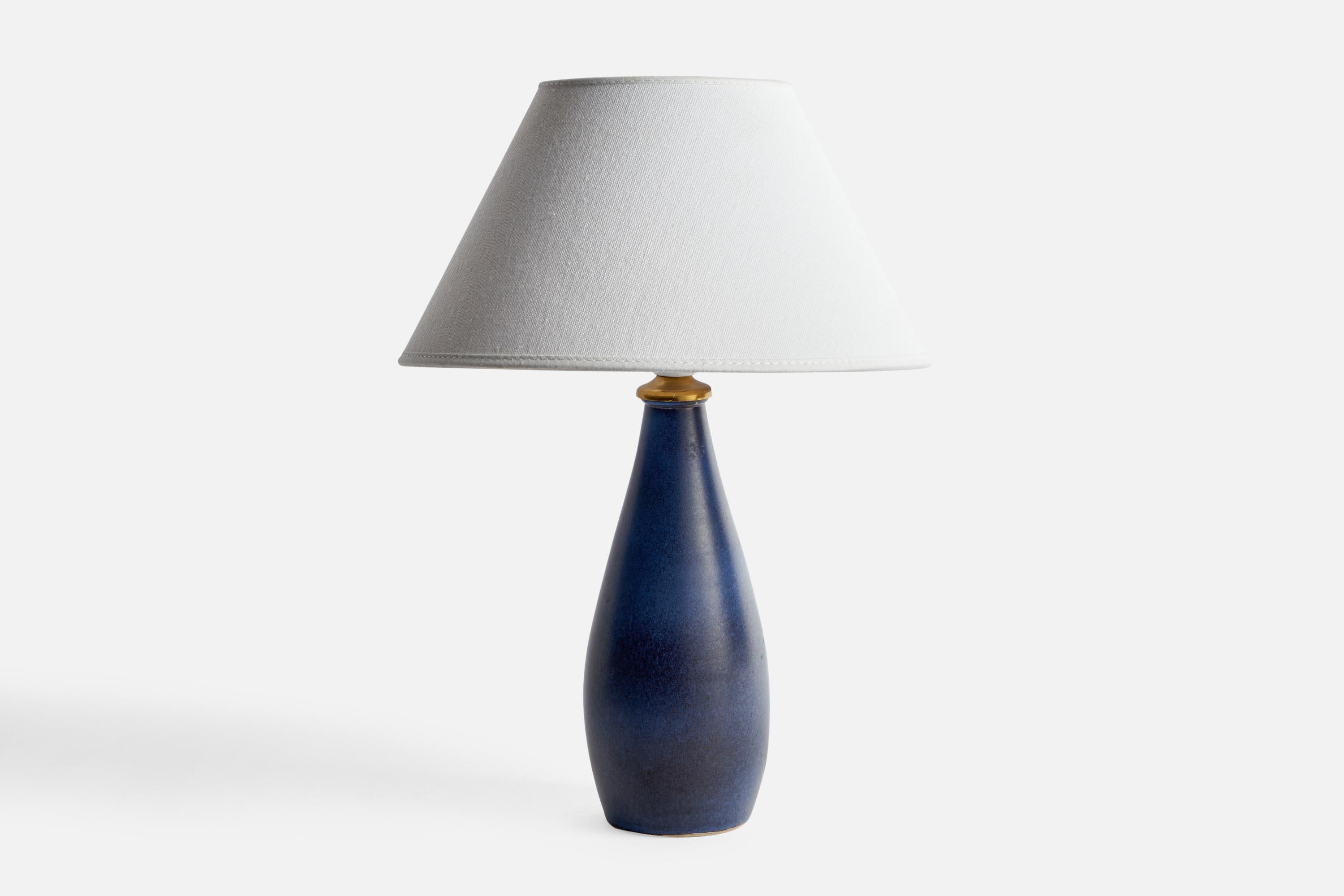 A blue-glazed stoneware and brass table lamp designed and produced by Klosterstad Ceramics, Sweden, c. 1960s.

Dimensions of Lamp (inches): 10.7” H x 3.55” Diameter
Dimensions of Shade (inches): 4.5” Top Diameter x 10” Bottom Diameter x 5.25”