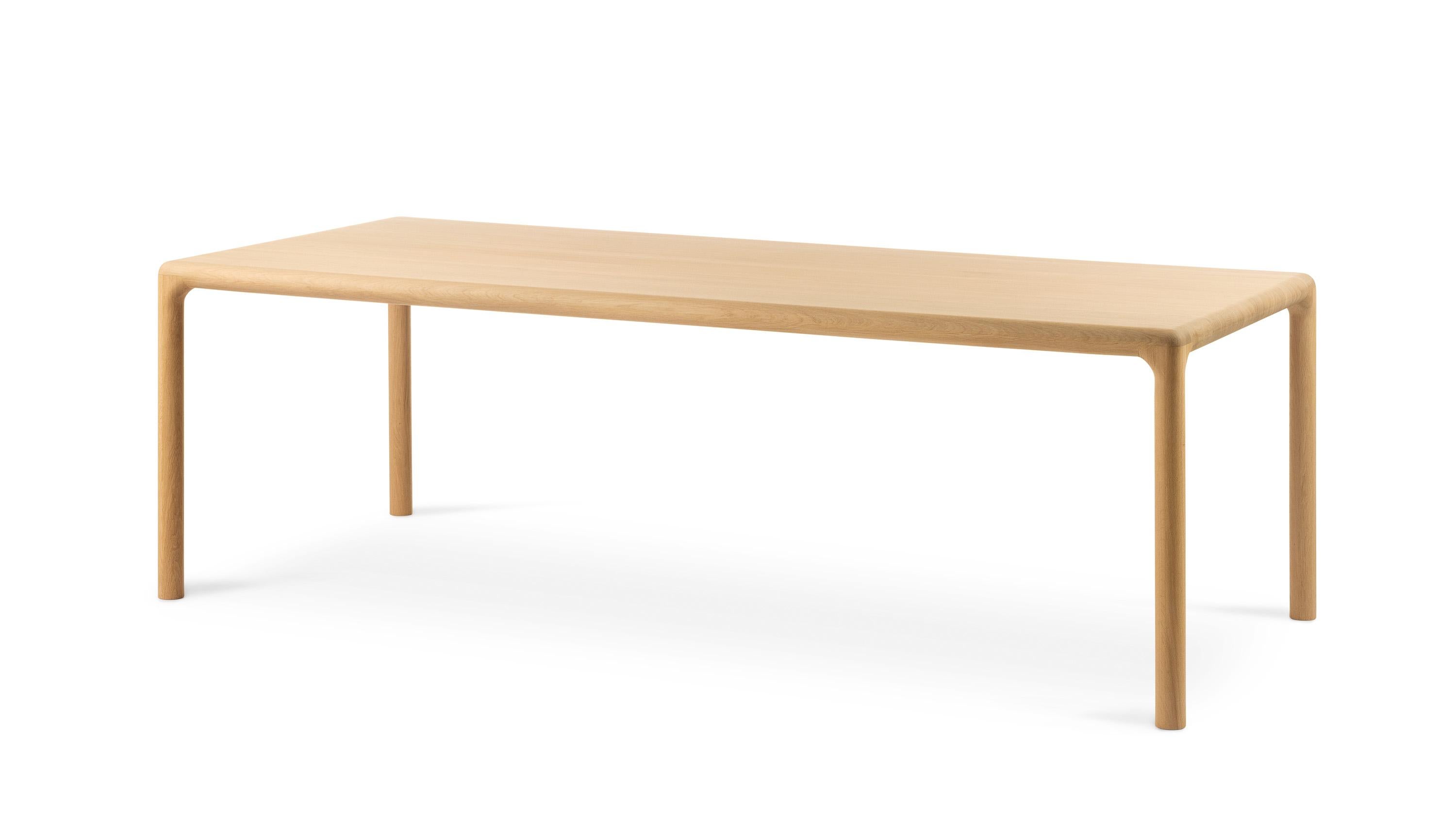 This 100% solid oak table is rectangular but not really. It is very beautifully rounded in an organic way. The top and legs are finished with a beautiful, soft radius. The edge invites you to grab it, so that you have contact with the solid wood and