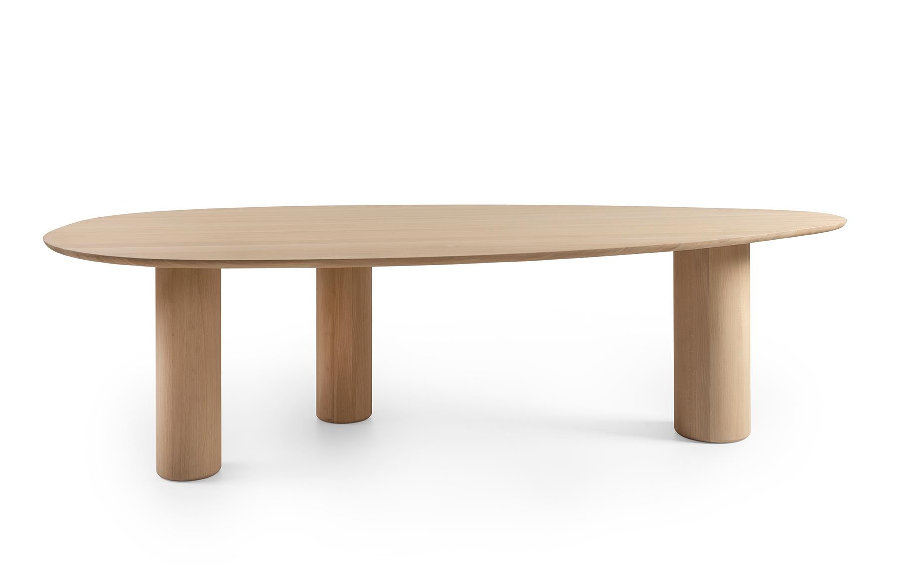 This 100% solid oak table is not round, not oval, not rectangular but very beautifully organic. The top is a bit asymmetrical and finished with a beautiful, soft radius. The edge invites you to grab it, so that you have contact with the solid wood