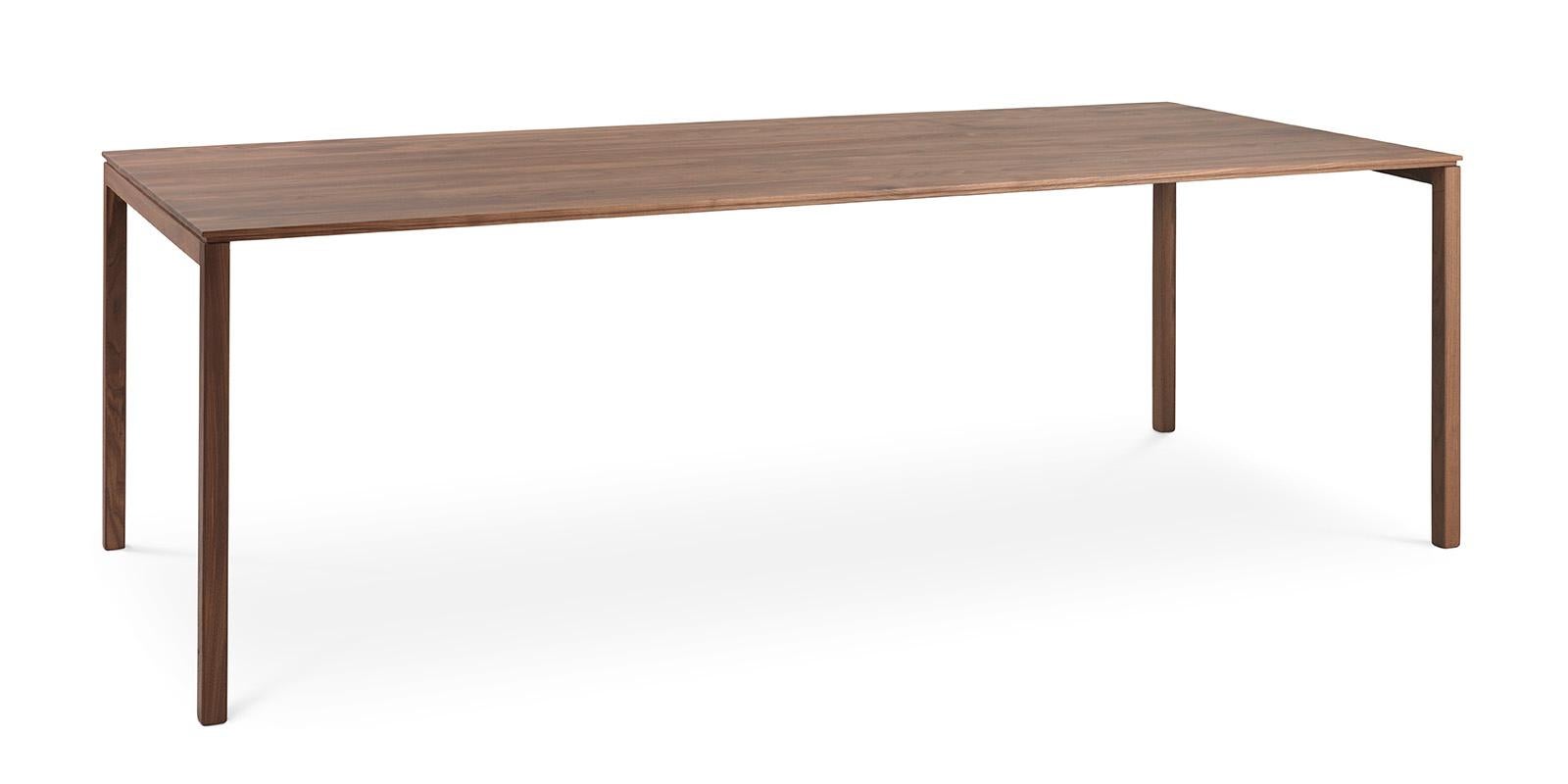 This massive table has been stripped of almost everything that is unnecessary. The legs are very refined and on the long sides it seems as if the top is not supported. Due to the clever subcutaneous metal construction, this table can be made up to