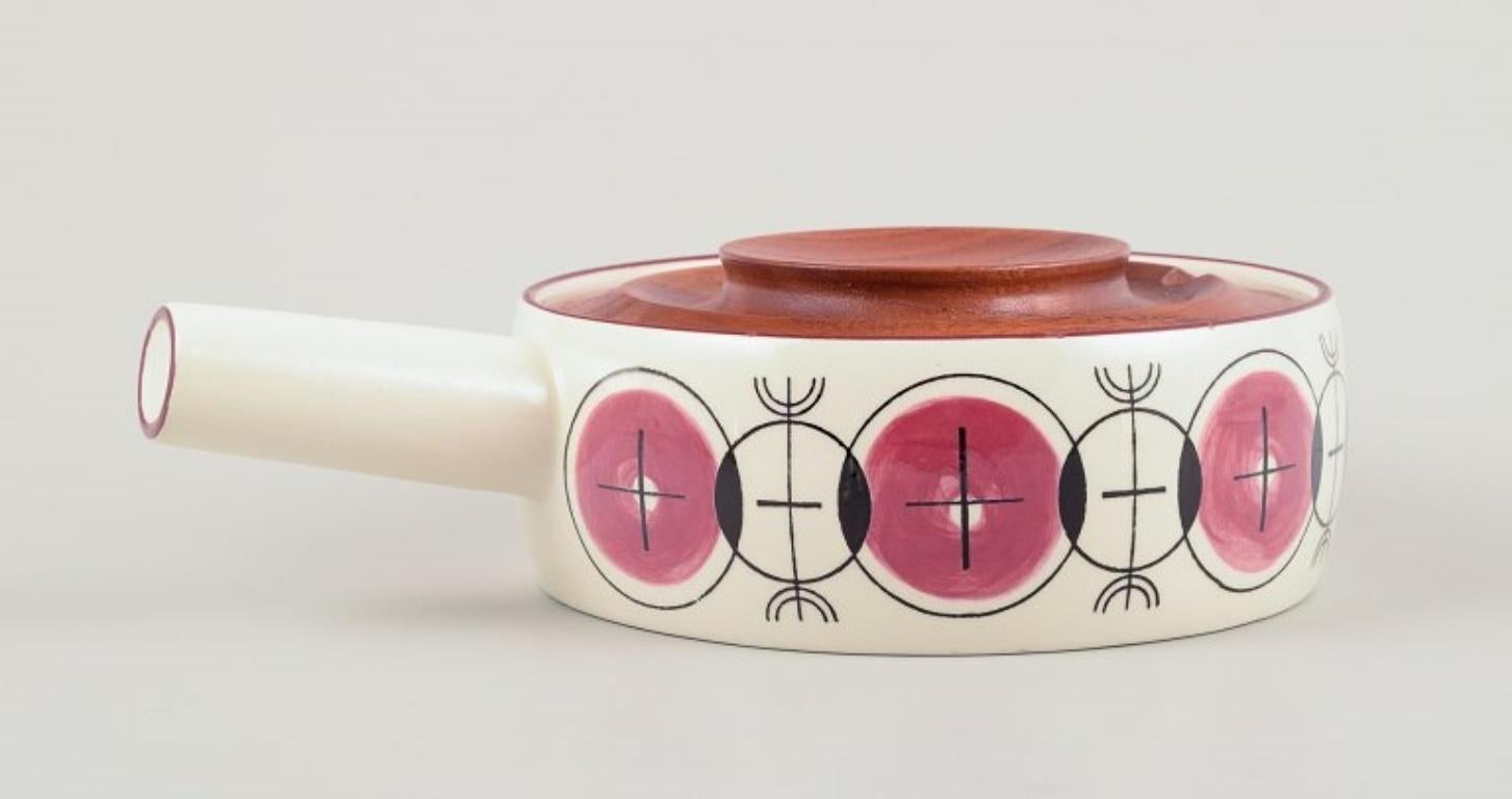 Knabstrup, Denmark.
Stoneware saucepan. With a wooden lid.
Modernist design with circles.
Circa 1970.
Marked.
In excellent condition with minimal signs of use.
Dimensions: D 16.0 cm. without handle x H 7.0 cm.



