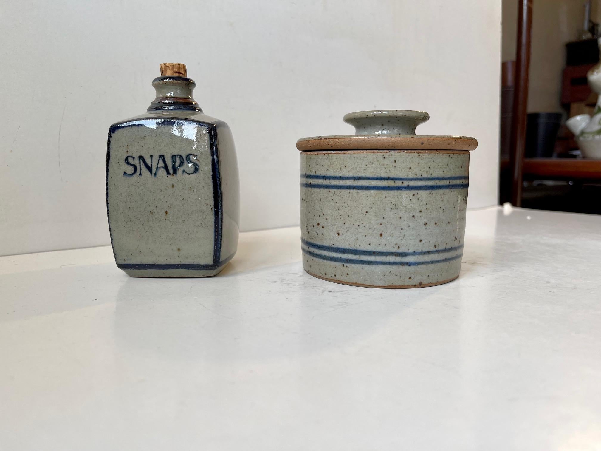 Two matching pieces from Knabstrup Atelje. Studio-made in Denmark circa 1970. The set consist of af small brandy decanter with cork stopper and a lidded jar. Snaps is the Danish equivalent of brandy. Scandinavian midcentury modern farmhouse style.