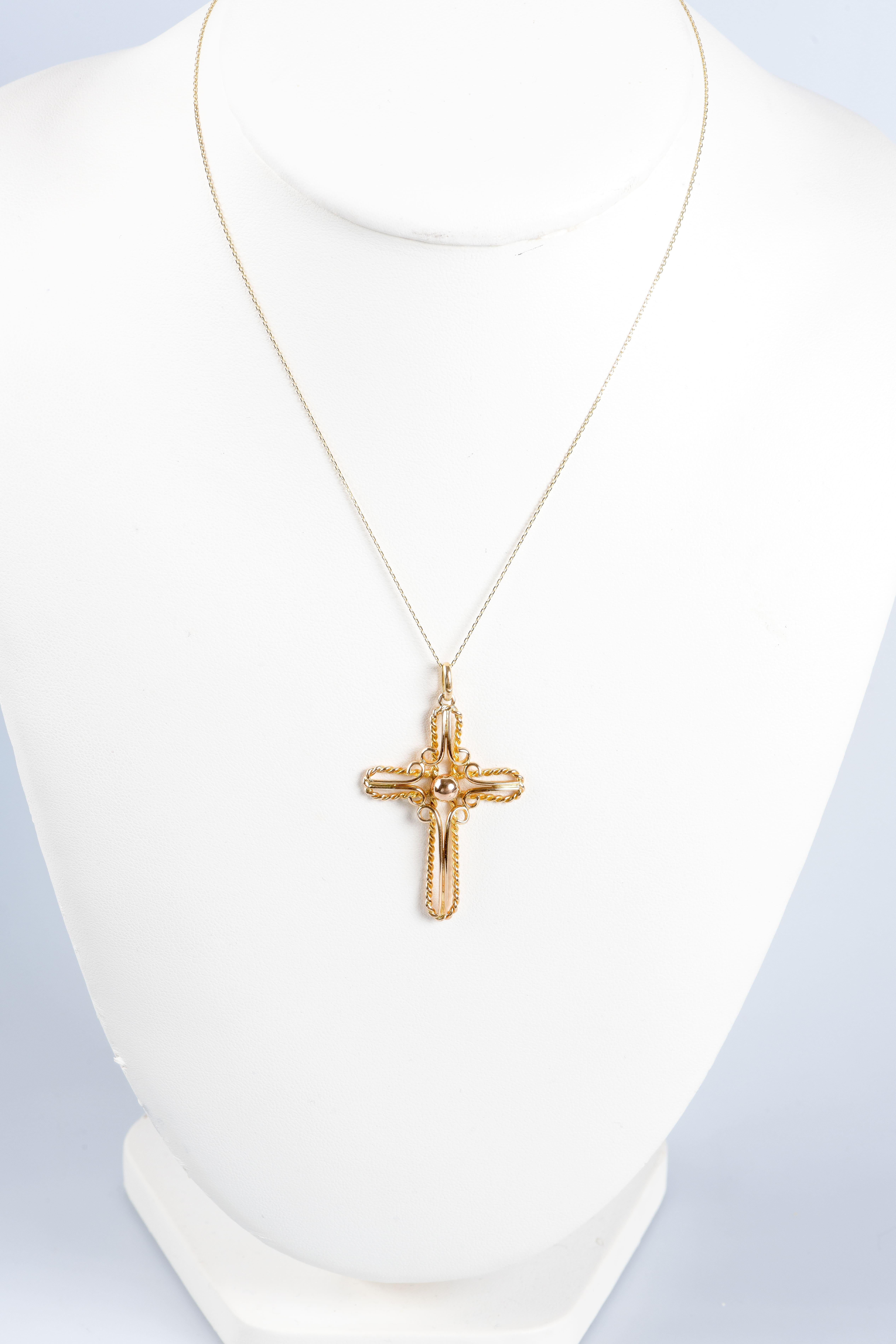 Knitted necklace with cross-shaped pendant in 18K yellow gold. The cross is made with gold thread and this technique allows to create a very fine and delicate jewel that highlights the beauty and brilliance of gold. The complex construction of the