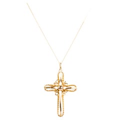 Knitted necklace with cross-shaped pendant in 18K yellow gold. 