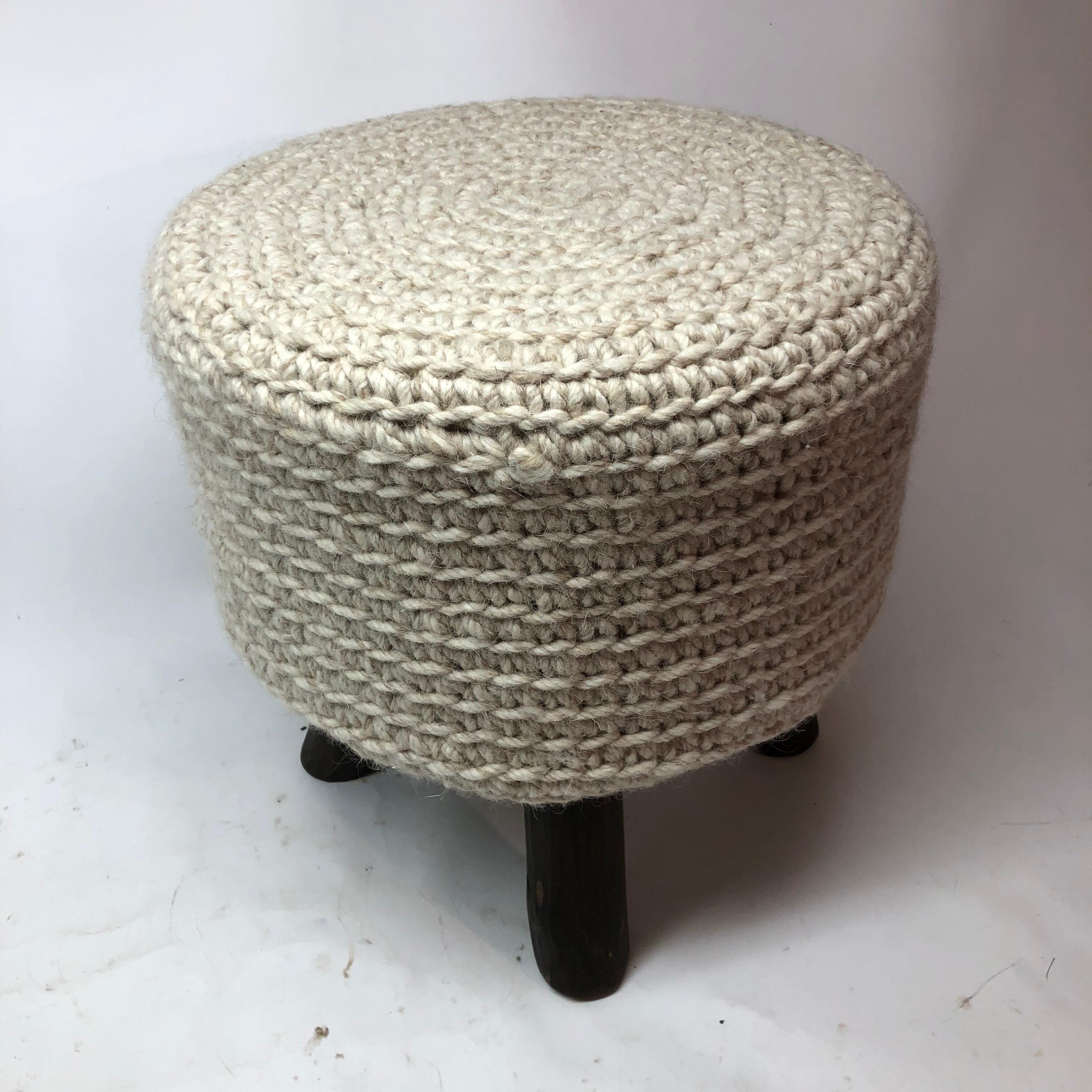 Knitted crochet wool stool with wood legs.