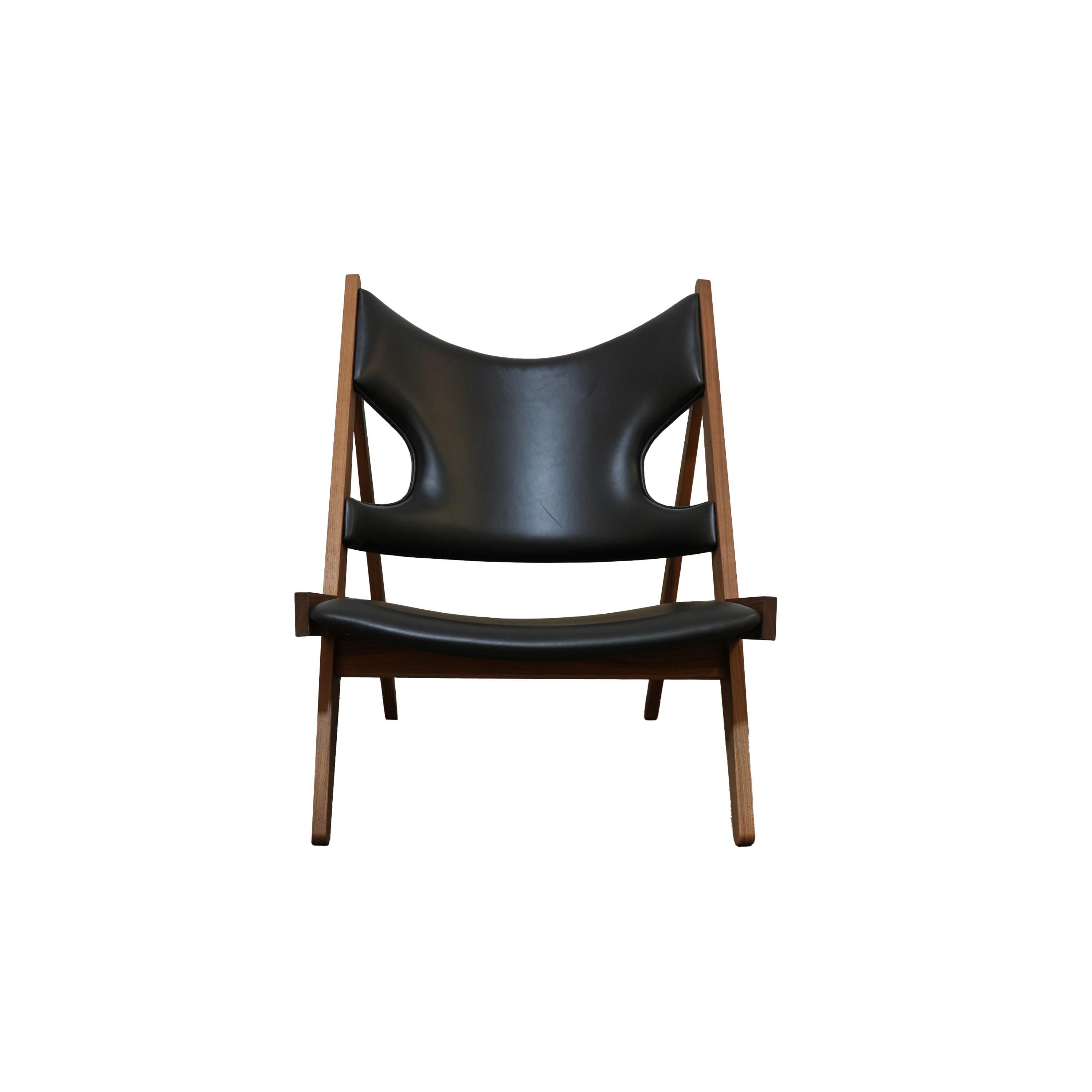 Defined by an exposed, triangular construction, a gently curved seat and back ideally pitched for relaxation, and distinctive cut-outs for resting the elbows when reading (or, of course, knitting), the Knitting Chair affirmed Kofod-Larsen’s