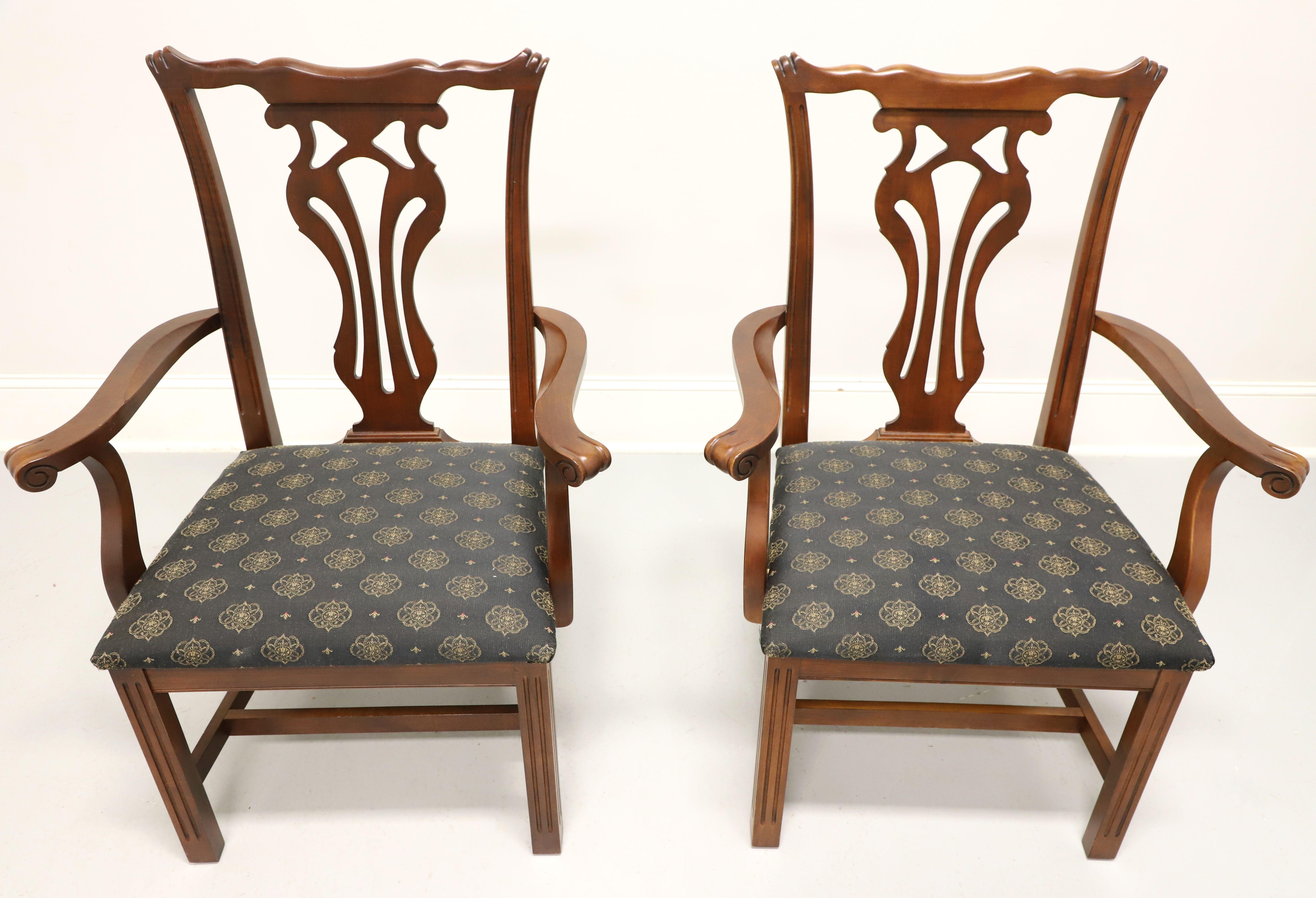 A pair of dining armchairs in the Chippendale style by Knob Creek.  Mahogany with carved backrests, curved arms, black & gold color fabric upholstered seat, stretcher base, and straight legs. Made in the USA, in the late 20th Century.

Measures: 
