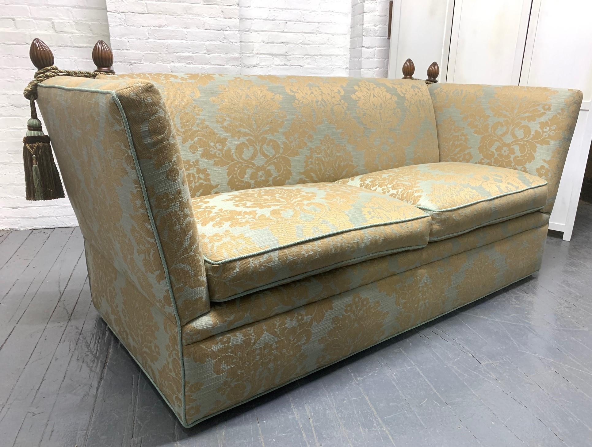 Divano Knole inglese con tappezzeria personalizzata. Il divano presenta corde e nappe avvolte intorno a terminali decorativi in noce con lati incernierati.