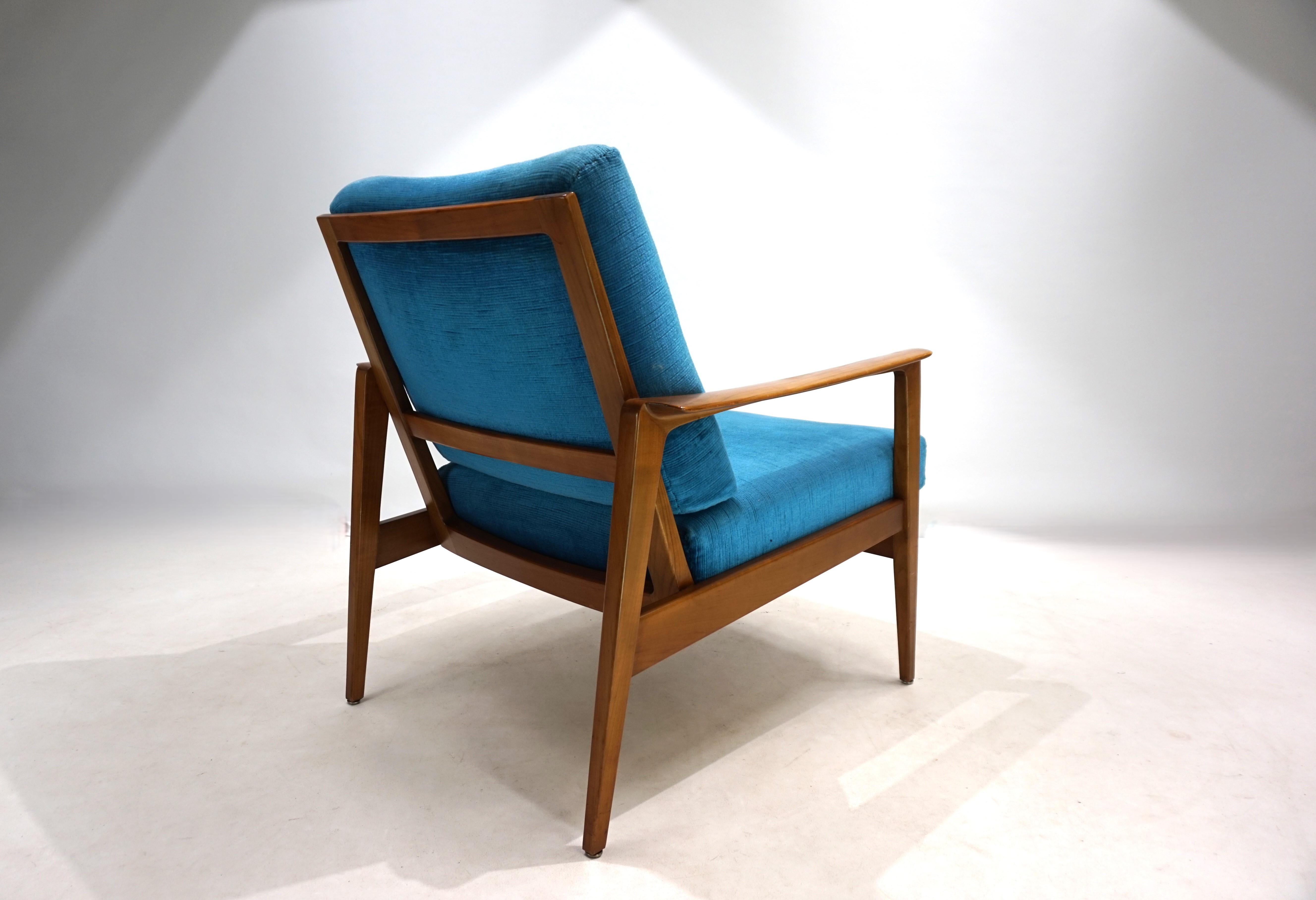 A fantastic lounge chair with classic Scandinavian design lines, it's in excellent condition. The walnut wooden frame shows only minimal signs of wear at the foot ends. All joints of the wooden frame are solid, and the classic Knoll springs are in