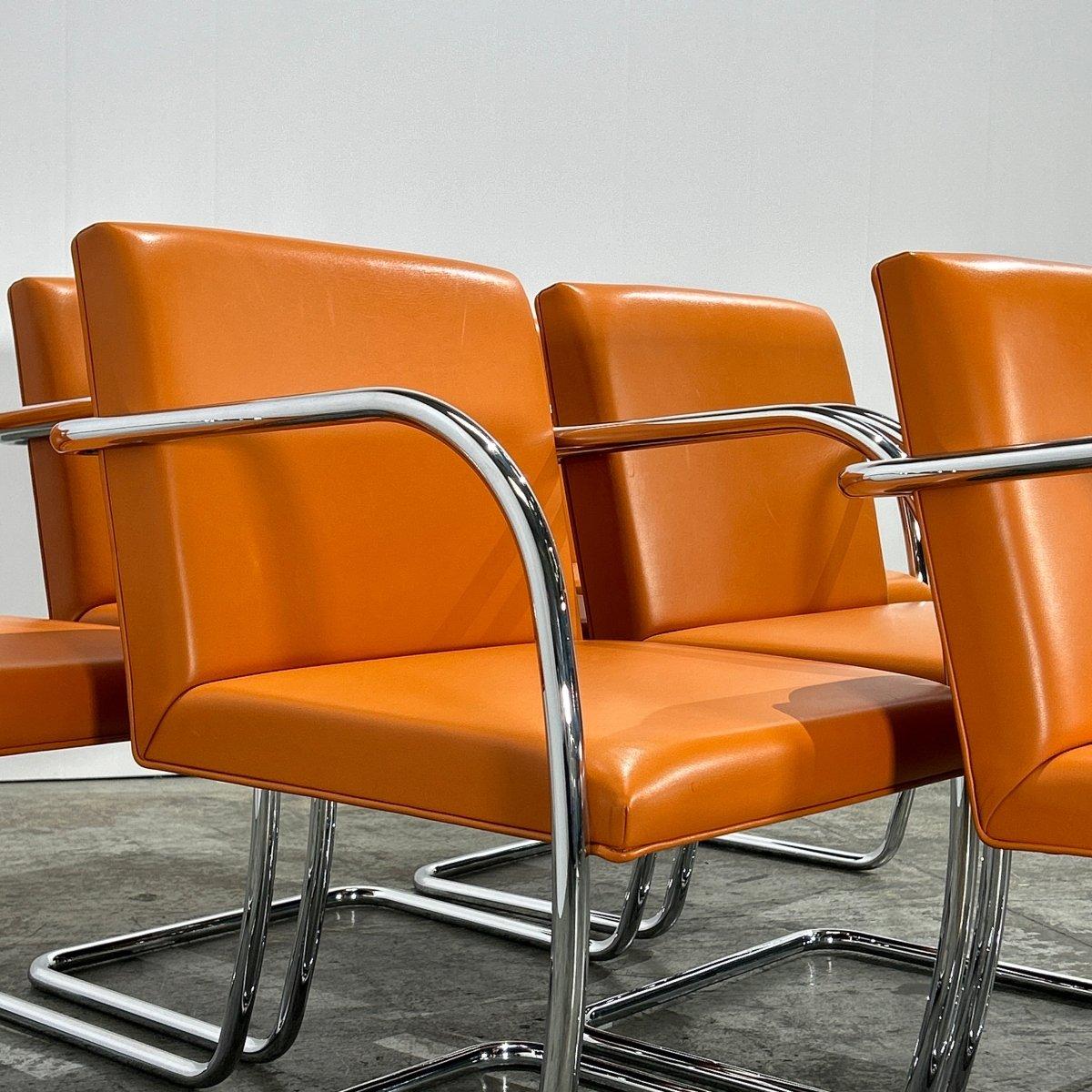 Introduci un tocco di eleganza senza tempo nel tuo spazio abitativo con la Sedia tubolare Brno in pelle arancione Tan di Ludwig Mies van der Rohe per Knoll. Questo pezzo iconico è caratterizzato da un'elegante struttura in tubolare d'acciaio e da un