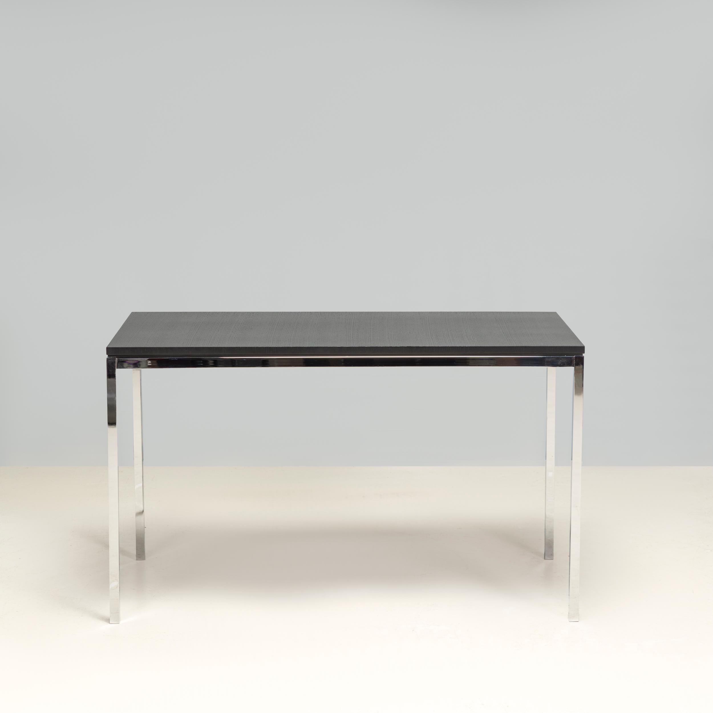 Originally designed by Florence Knoll in 1954, the Mini Desk is part of the High Table range manufactured by Knoll.

Constructed from a slimline polished chrome frame, the desk has an ebonised oak veneer tabletop.

Sleek and sophisticated, the