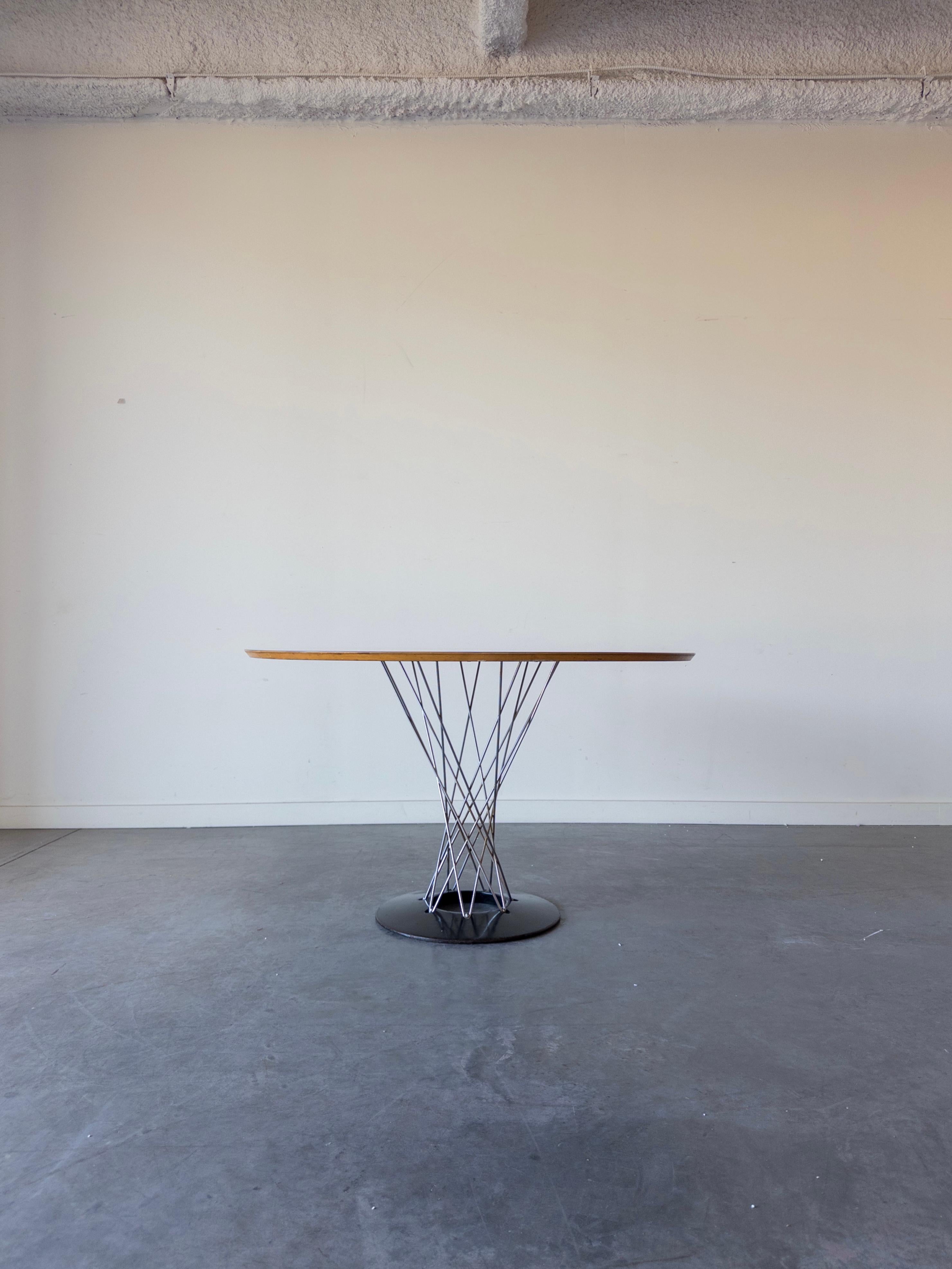 Pareja de mesas auxiliares Knoll Cyclone, modelo 311, diseñadas por Isamu Noguchi para Knoll. Este ejemplo data de los años sesenta. La pieza tiene una base de hierro fundido recubierta de esmalte de porcelana negra y una encimera de laminado