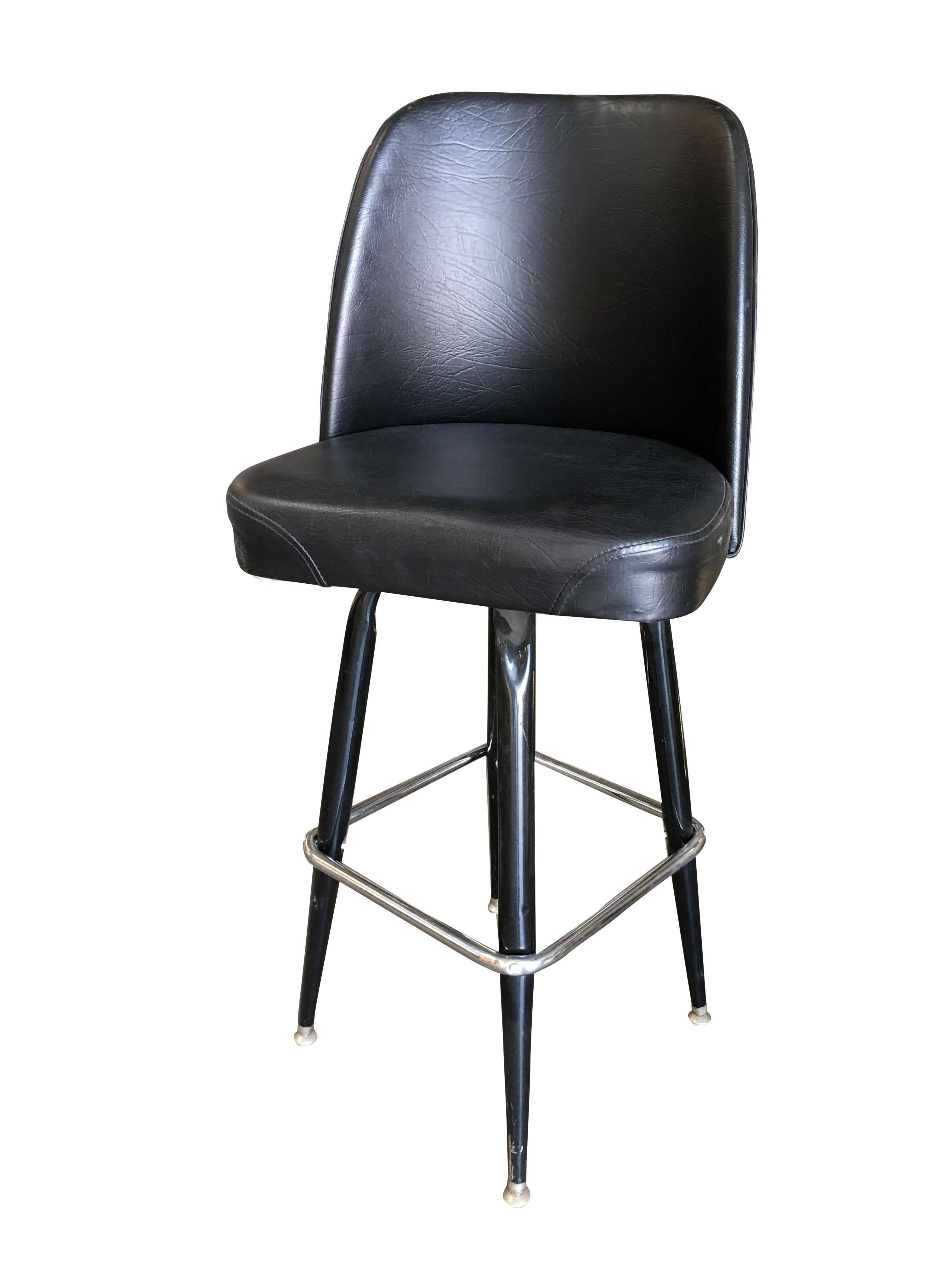Set of four Knoll inspired Modernist style bar stool featuring a soft lounge like bucket seat on black pounder coat steel base with chrome footrest.
