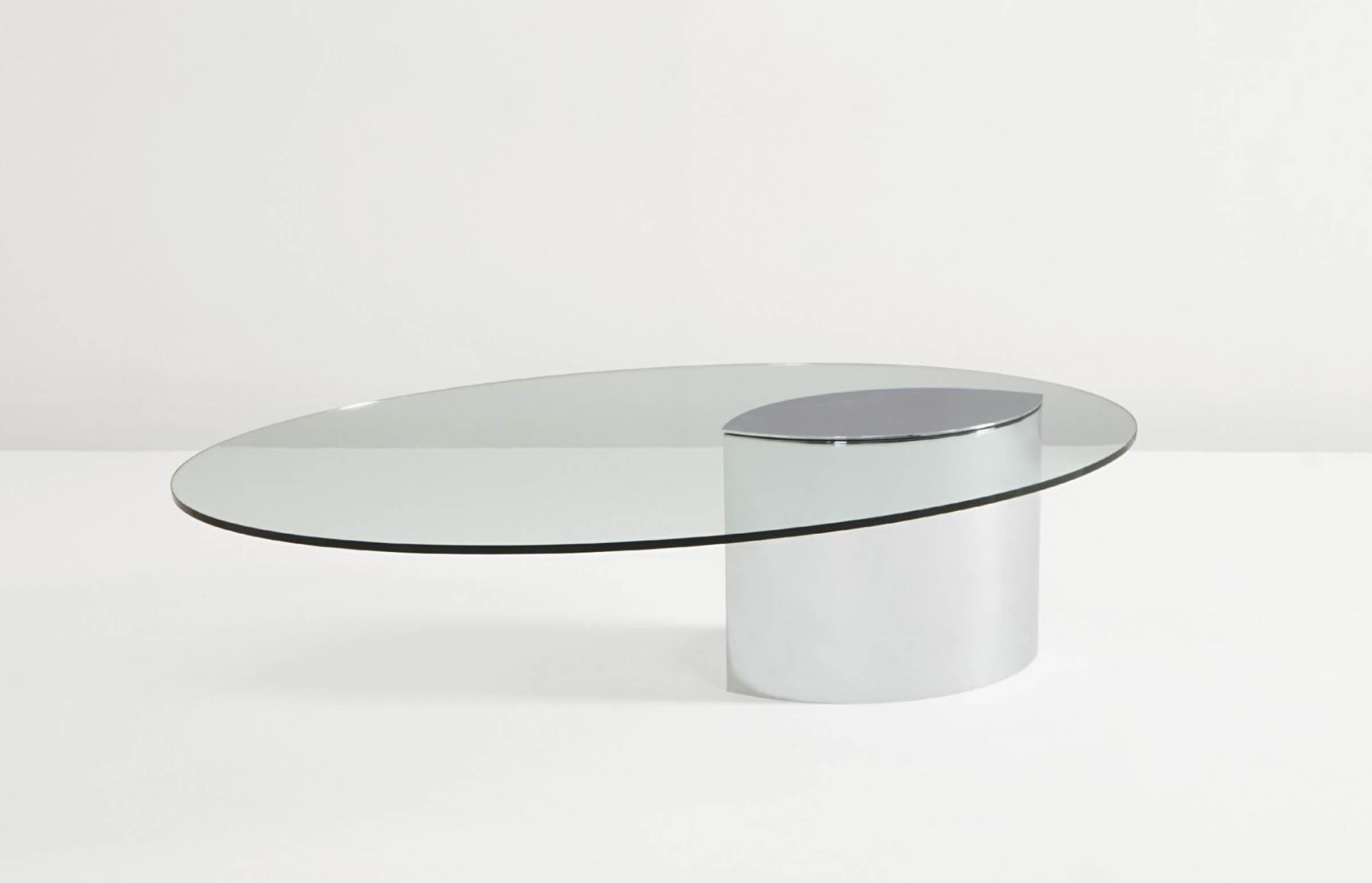 Originally designed in the 1970 the Lunario table series is a unique cantilevered table.
The tabletop is a clear oval glass with polished stainless steel intert cap which sits upon a glossy massive stainless steel base. Weights within the base