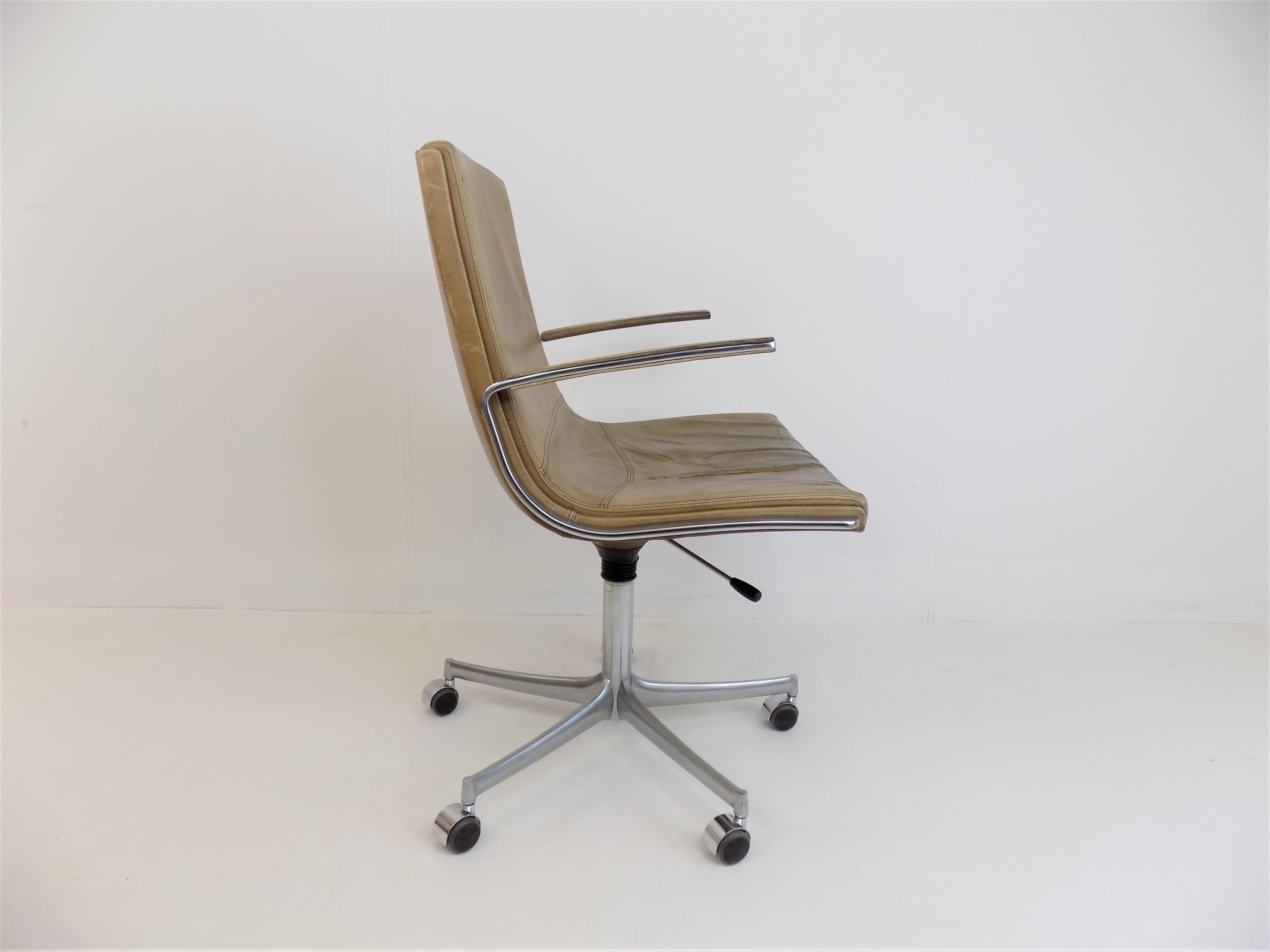 The Logos office chair in cognac-colored leather is in good condition. The leather is soft and shows a age-appropriate patina and signs of wear. The stainless steel armrests are in very good condition, as is the star base. The leather covering of