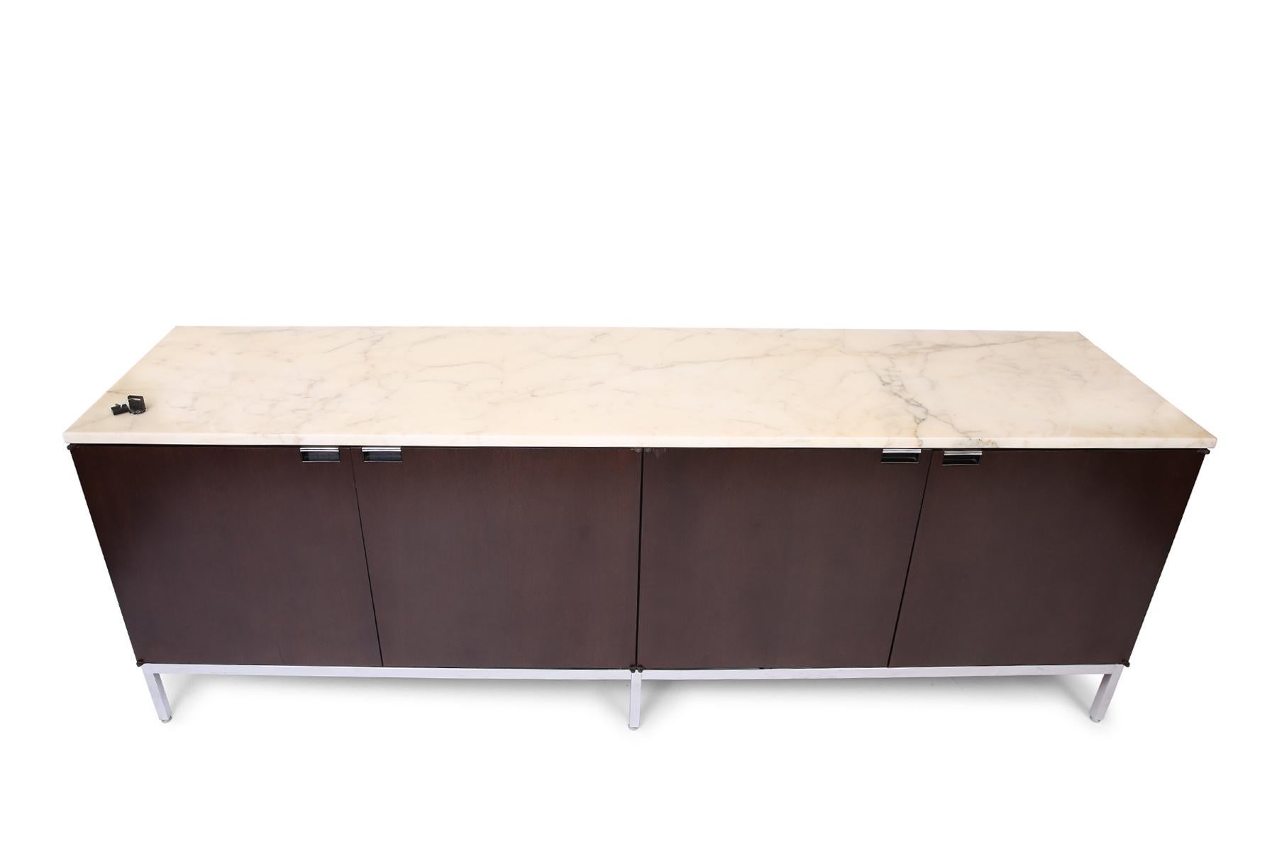 Stunning Florence Knoll designed credenza with original Italian white Calacatta marble top, including rare top locking mechanism. Four dark mahogany finished doors open to reveal a total of eight oak shelves. Finished with polished chrome-finished