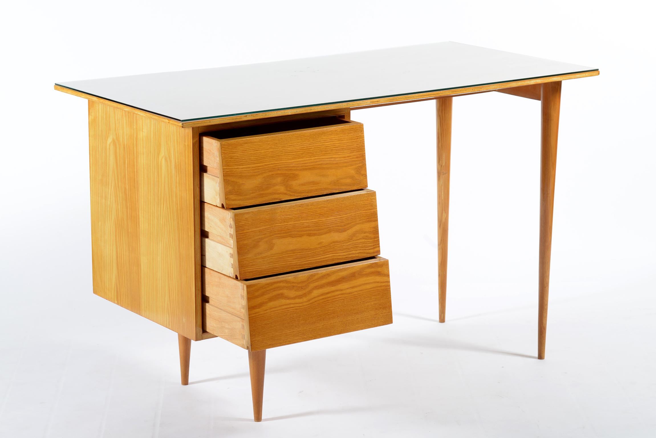 Midcentury squared writing desk by Knoll Florence international in ashwood.
Three drawers in the left side and four conical high legs, glass top to protect the wood surface.
 
 