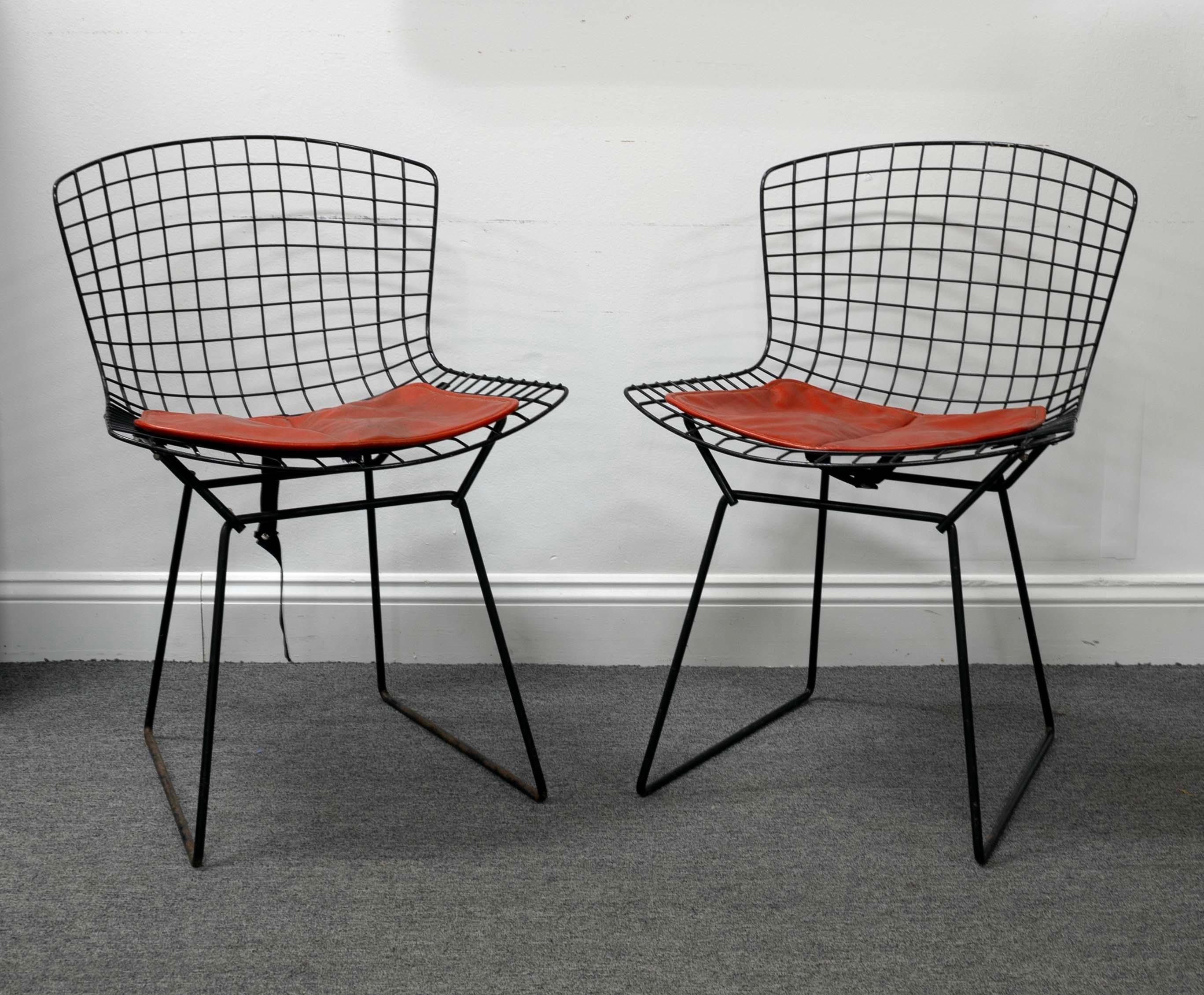 Elevate your living space with this striking pair of Vintage Black Iron Wire Bertoia Chairs by Knoll, perfect for adding a touch of mid-century charm to any interior. The iconic grid design creates an open, airy feel, while the red cushions provide