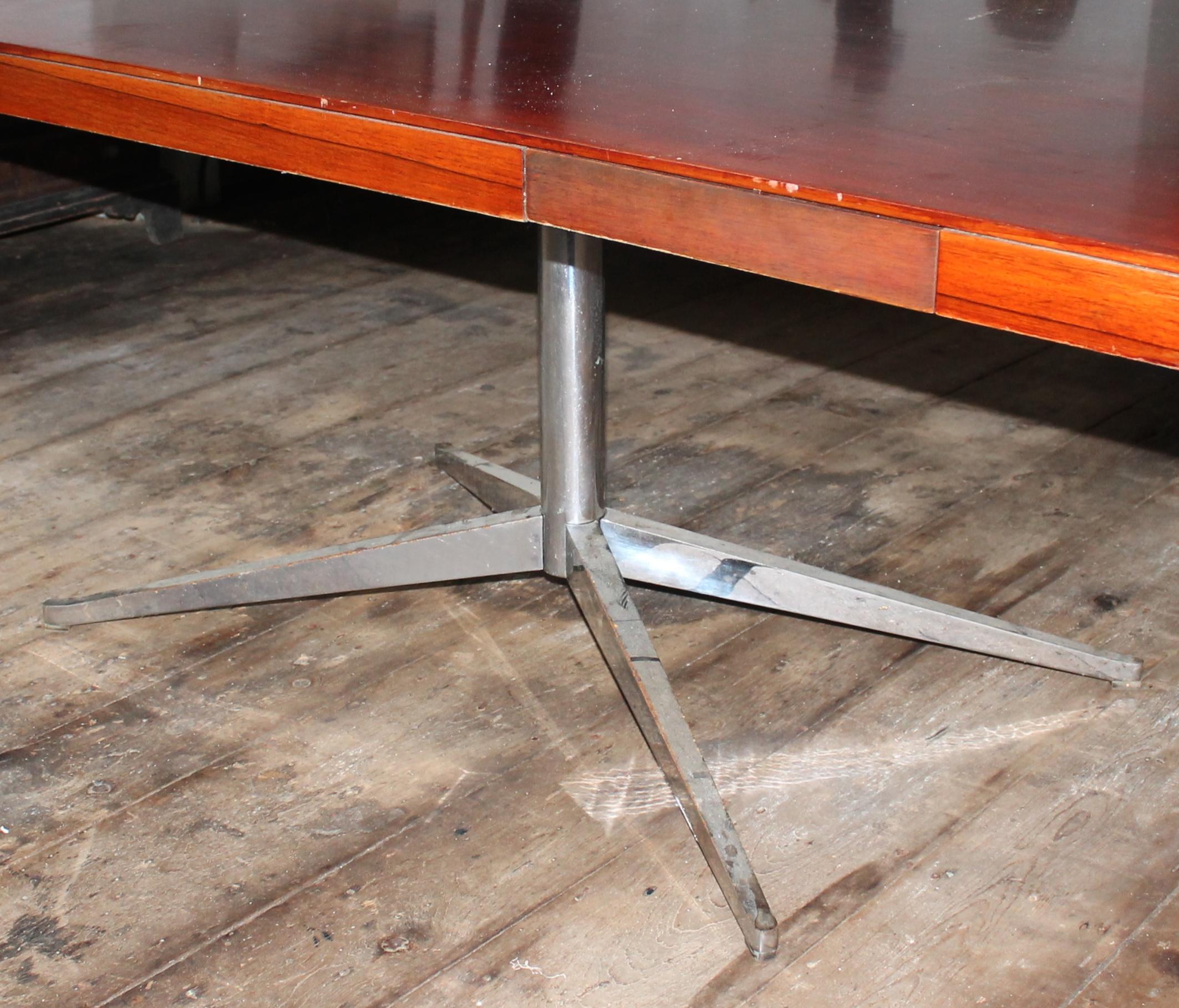 The Classic Knoll Partners desk, or dining table with four drawers in rosewood on steel pedestal base.