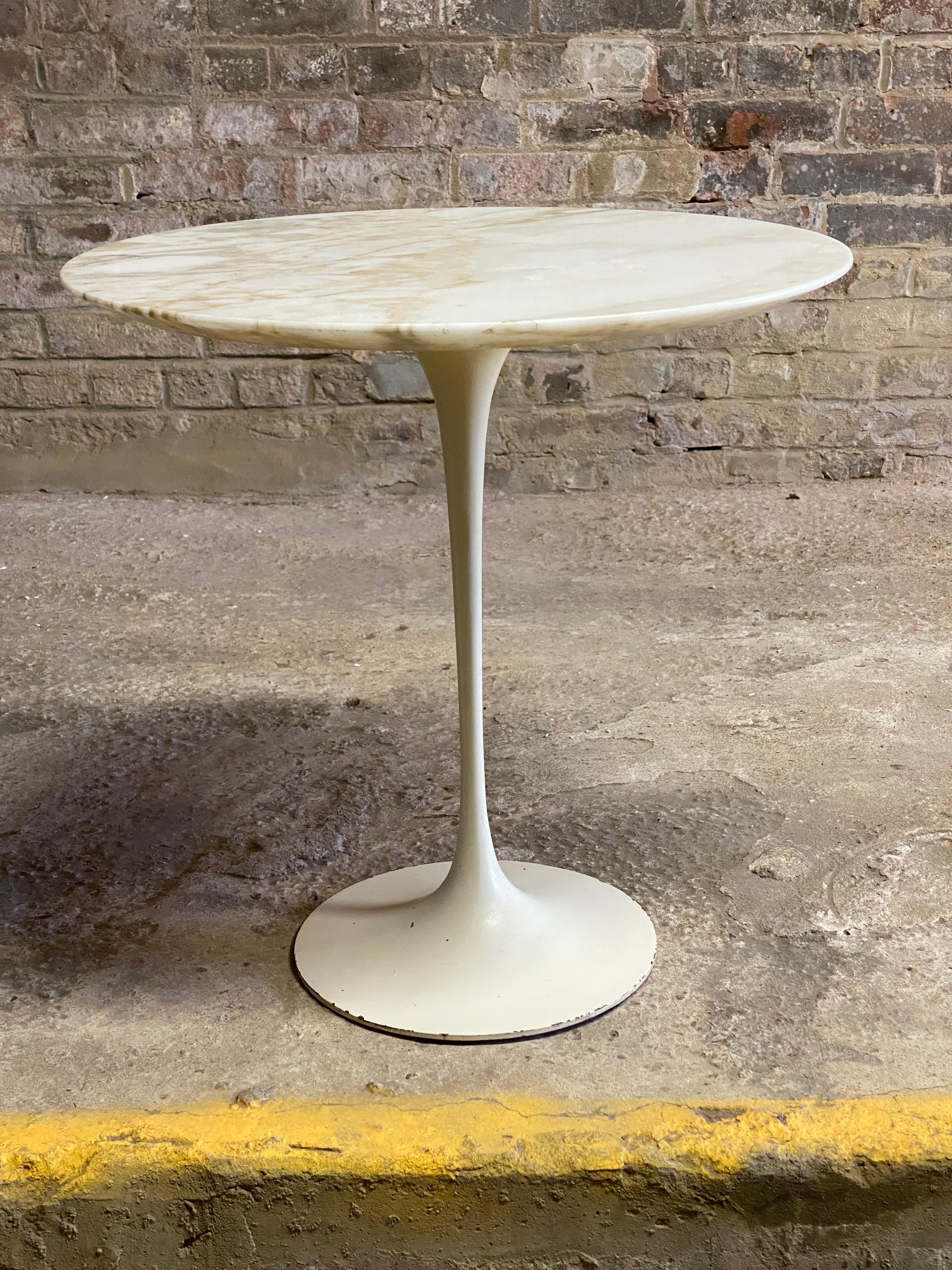Classic Eero Saarinen for Knoll marble top tulip table. Sculptural cast aluminum base with a beveled white marble with tan and grey veining. This example dates circa 1960-1970. Good overall condition with minor enamel losses on the edge of the base