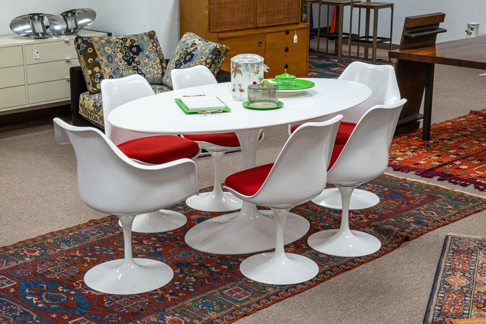 A Knoll Saarinen mid century modern white and red tulip dining set. An incredible set from legendary designer Eero Saarinen for Knoll furniture. This amazing dining set includes a large oval tulip dining table, 2 tulip arm chairs, and 4 tulip side