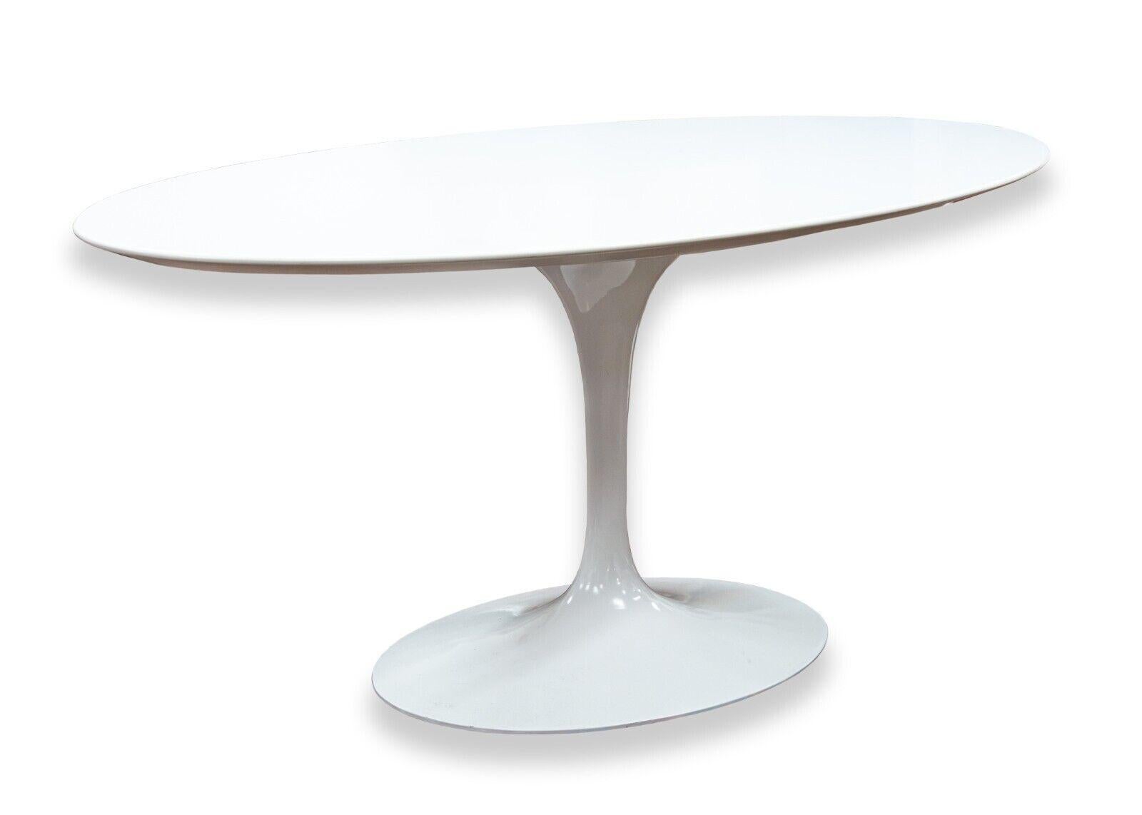 A Knoll Saarinen white oval tulip dining table. As a staple of mid century modern design, Eero Saarinen's tulip table will never go out of style. This piece, manufactured by Knoll, features a super chic and modern tulip base made out of a cast