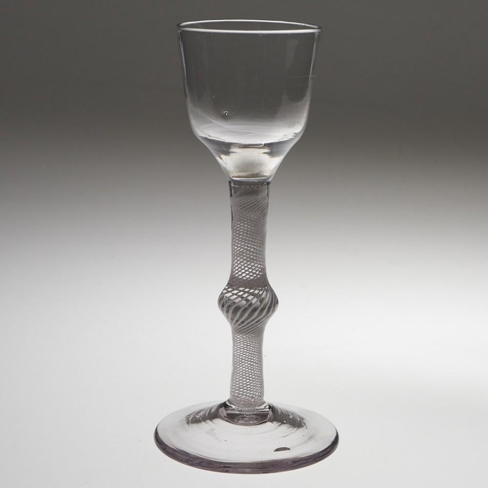 Heading : Opauqe twist stem wine glass
Period : George III - c1760
Origin : England
Colour : Clear
Bowl : Round funnel
Stem : Multi-series opaque twist with central flattened knop
Foot : Conical
Pontil : Snapped
Glass Type : Lead
Size :  15.6cm