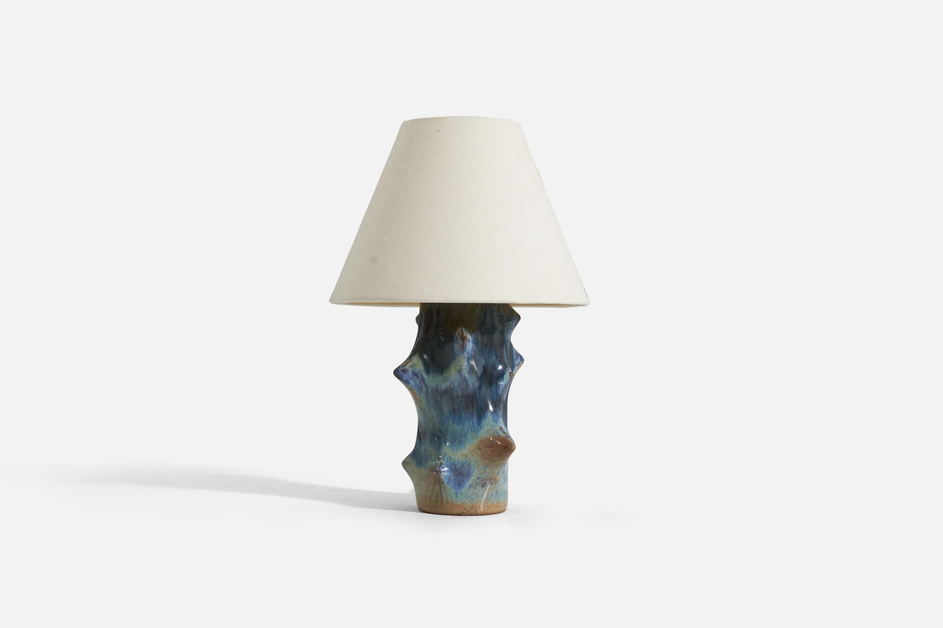 A blue and brown-glazed stoneware table lamp designed by Danish ceramicist Knud Basse, produced by Michael Andersen, Denmark in partnership with danish lamp manufacturer Lyfa. 

Measurements listed are of the lamp itself. Sold without