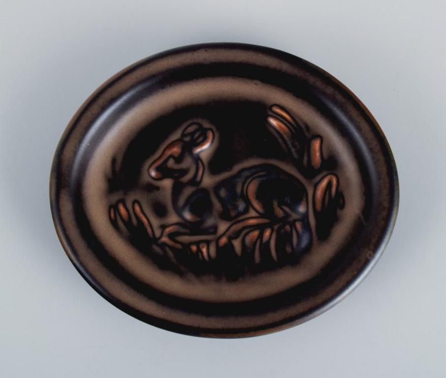 Knud Kyhn (1880-1969) for Royal Copehagen.
Small ceramic dish with a motif of a reclining deer.
Model number 21664.
In perfect condition.
Marked.
First factory quality.
Dimensions: L 10.5 x W 9.0 X H 1.5 cm.