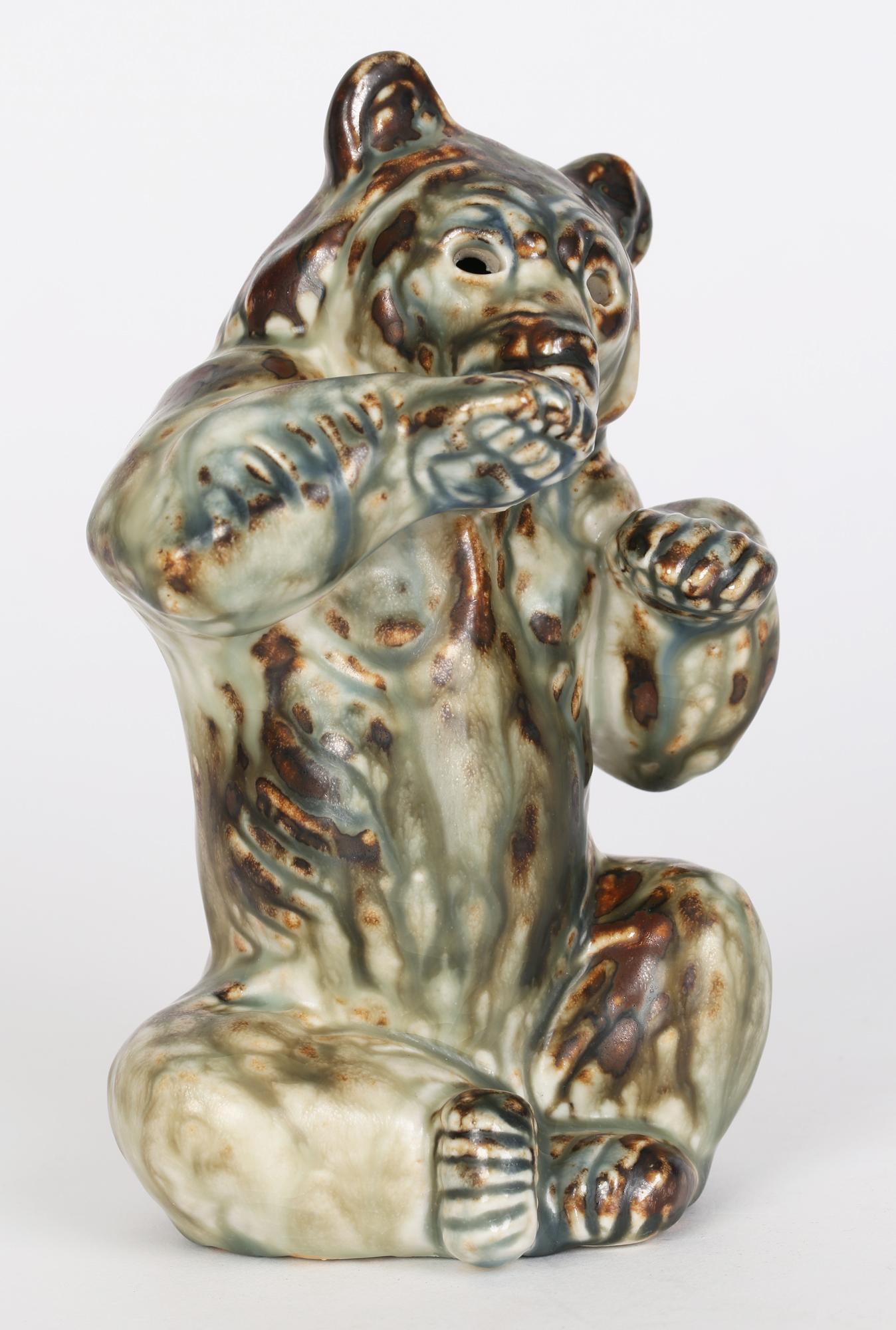 Une étonnante figure sculpturale en porcelaine de Royal Copenhagen représentant un ours assis, réalisée par le célèbre artiste animalier Khud Kyhn (danois, 1880-1969) et conçue vers 1935. L'ours est modelé en position assise et se lèche la patte